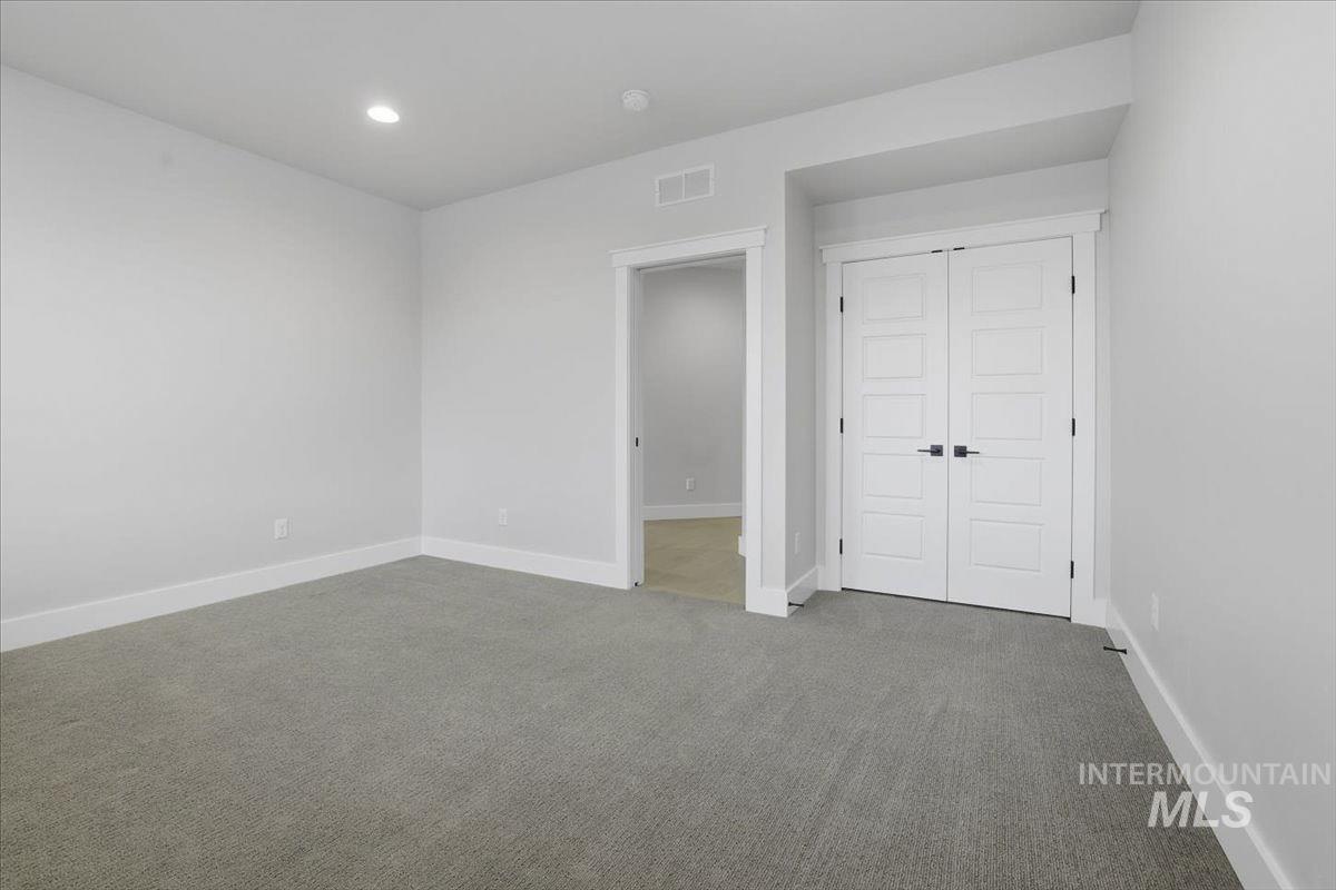Unfurnished bedroom featuring carpet floors, a closet, and recessed lighting