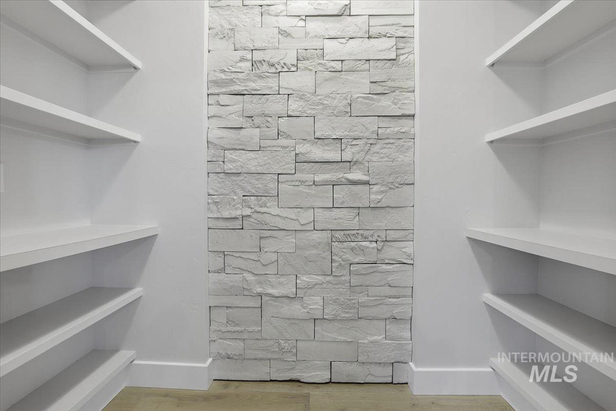 Walk in closet with light wood-type flooring