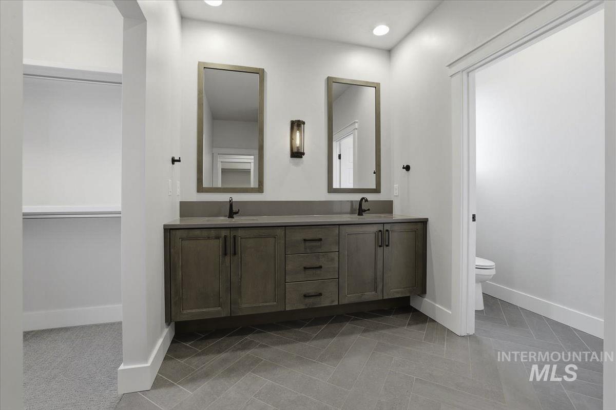 Bathroom featuring double vanity, recessed lighting, and a walk in closet