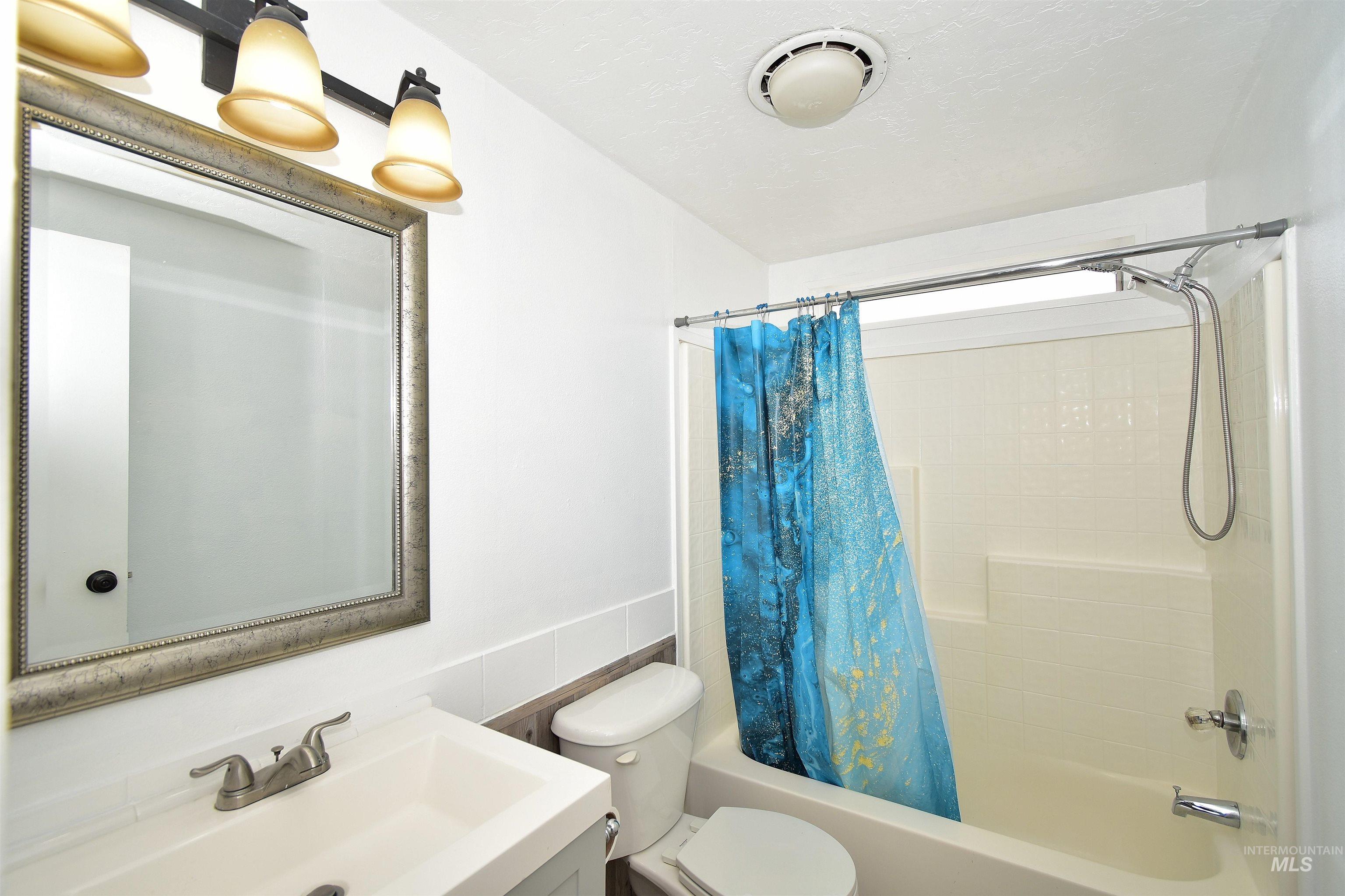 Bathroom featuring vanity and shower / bath combo with shower curtain