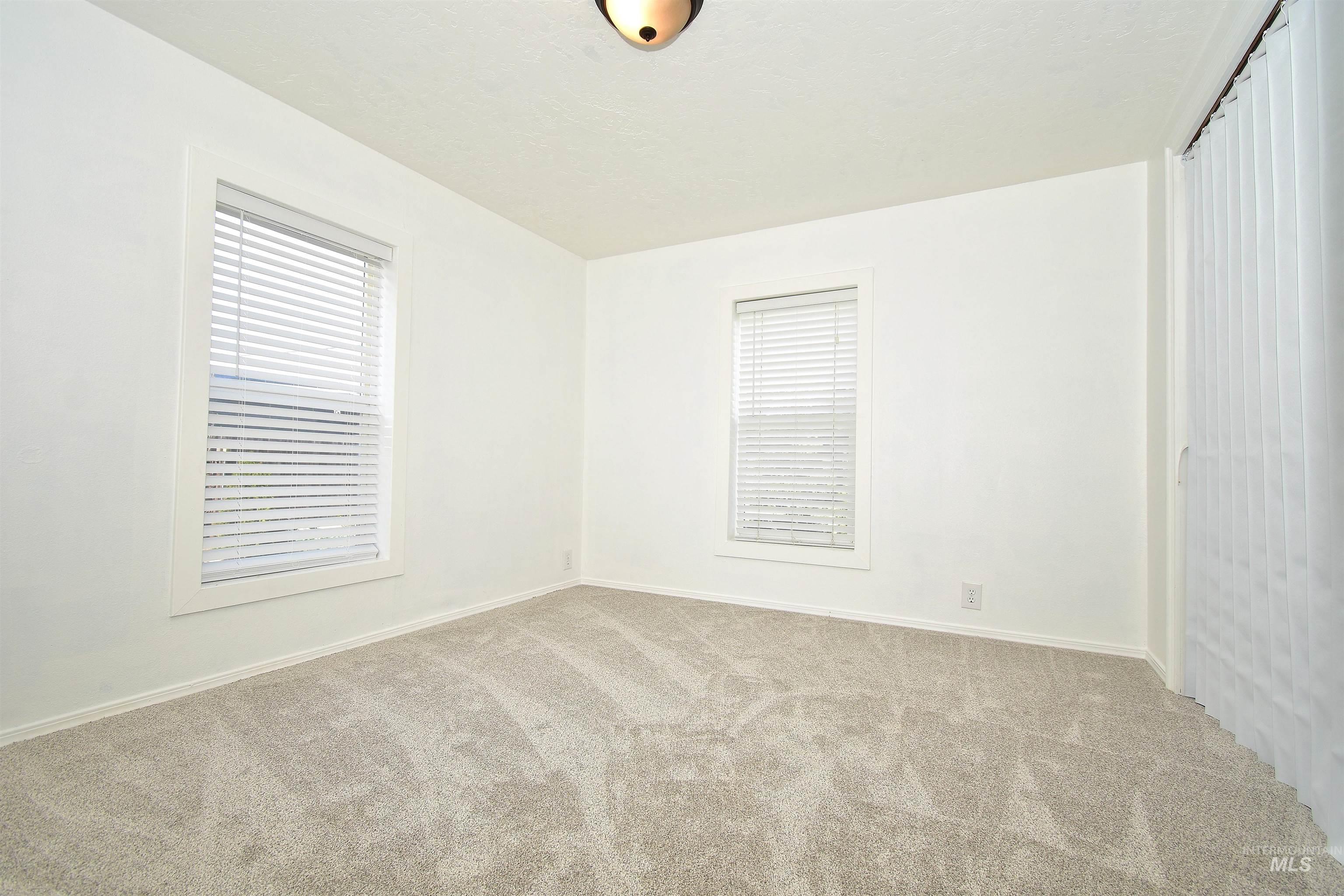 Unfurnished room featuring carpet floors and baseboards