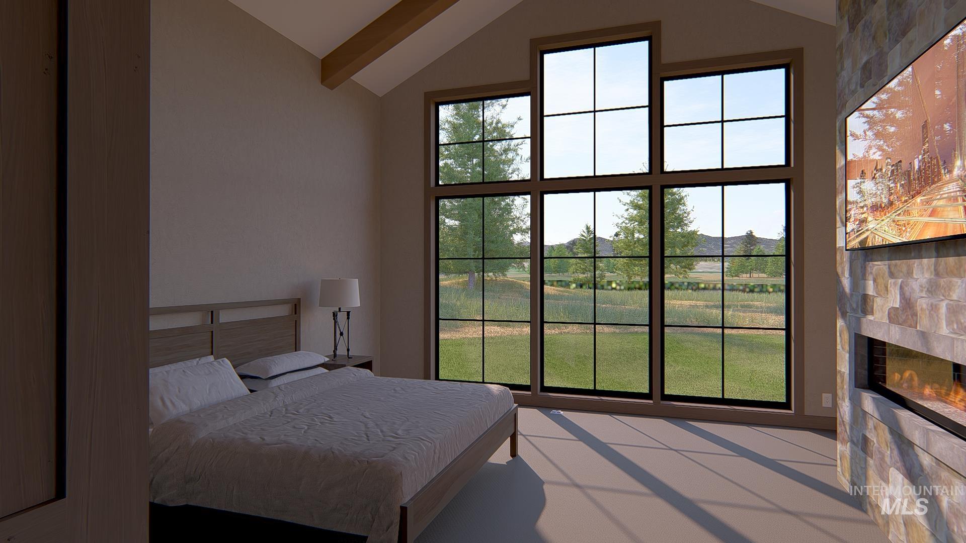 Bedroom with vaulted ceiling, a tile fireplace, and multiple windows
