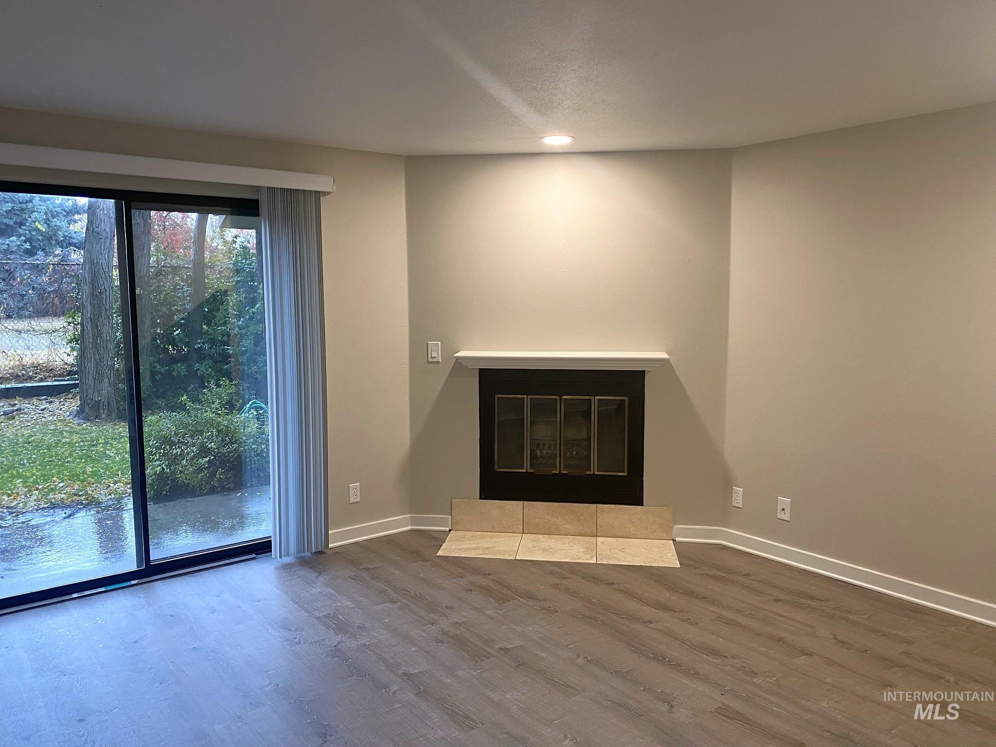 Unfurnished living room with wood finished floors and a fireplace