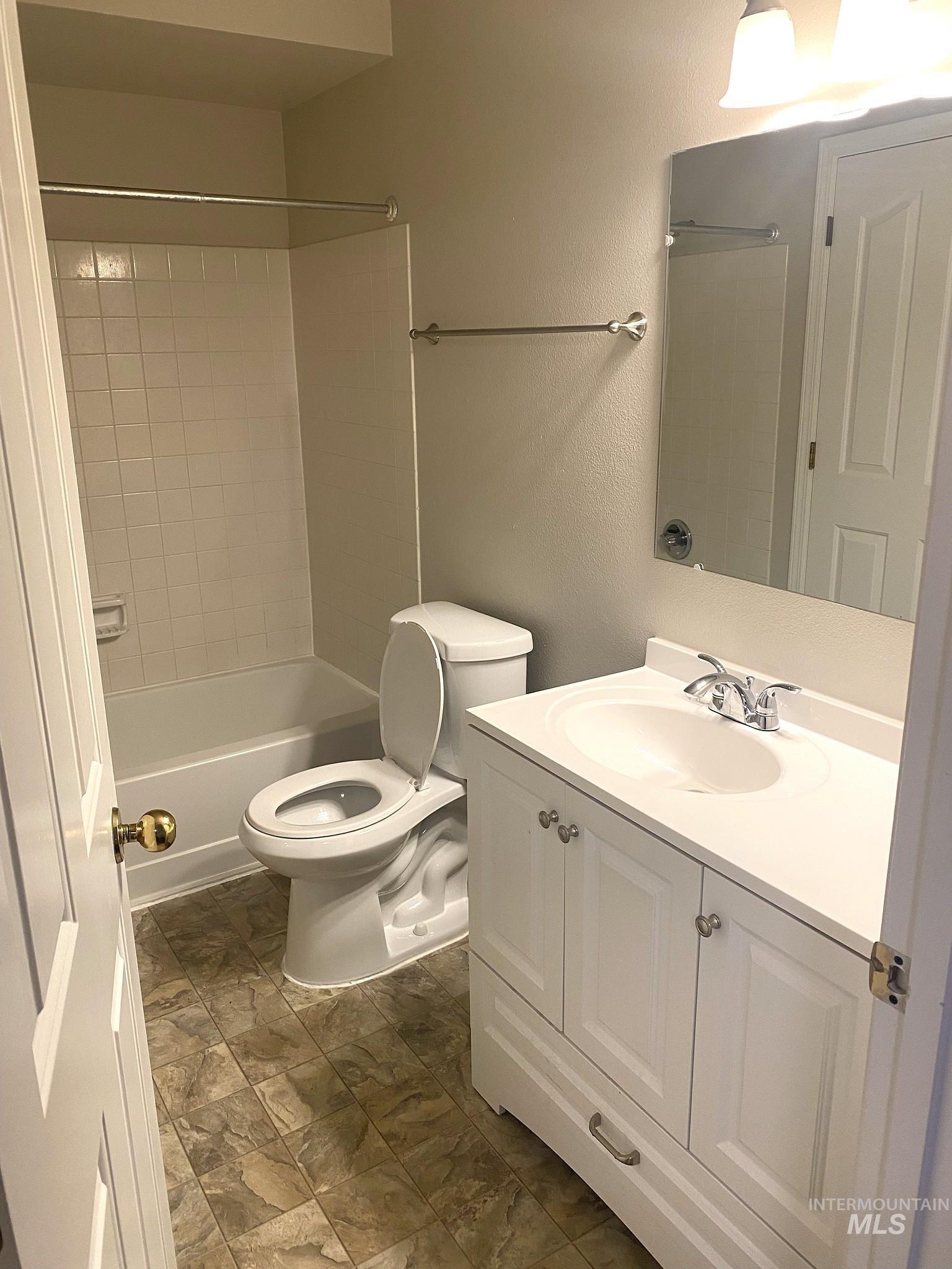 Full bathroom with vanity, shower / washtub combination, and a textured wall