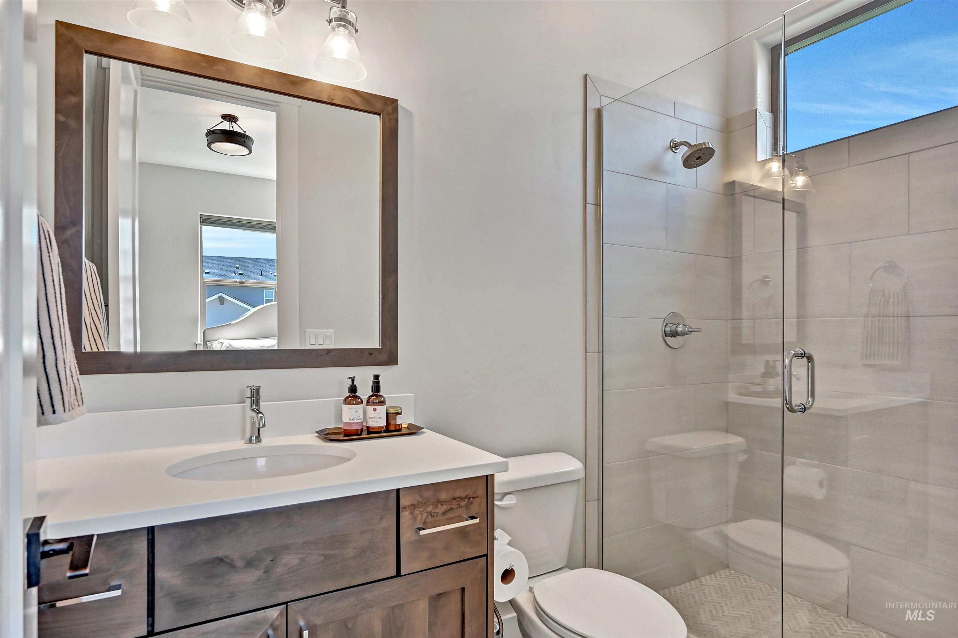 Full bathroom with vanity and a stall shower