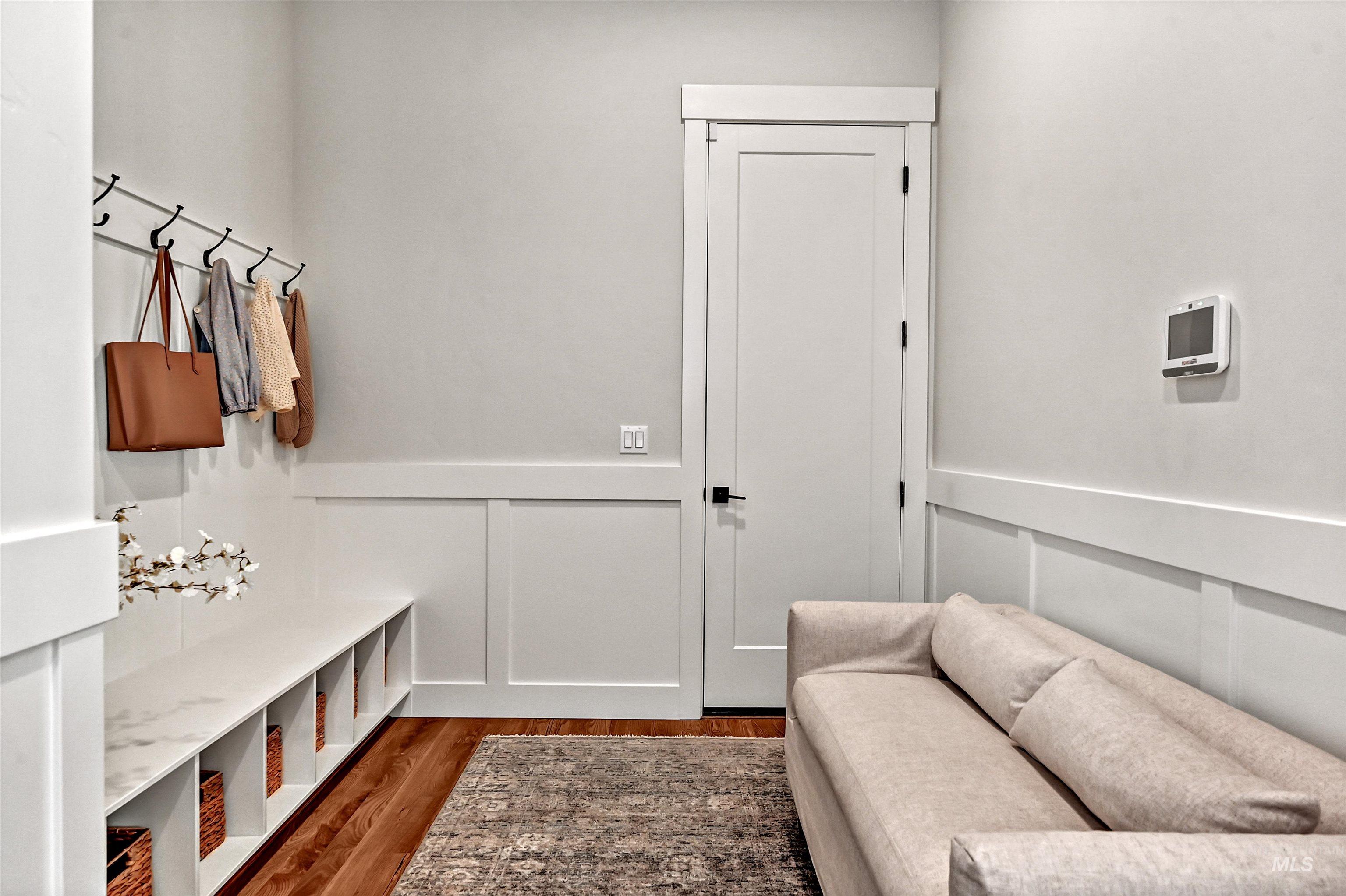 Mudroom featuring a decorative wall, a wainscoted wall, and dark wood-type flooring