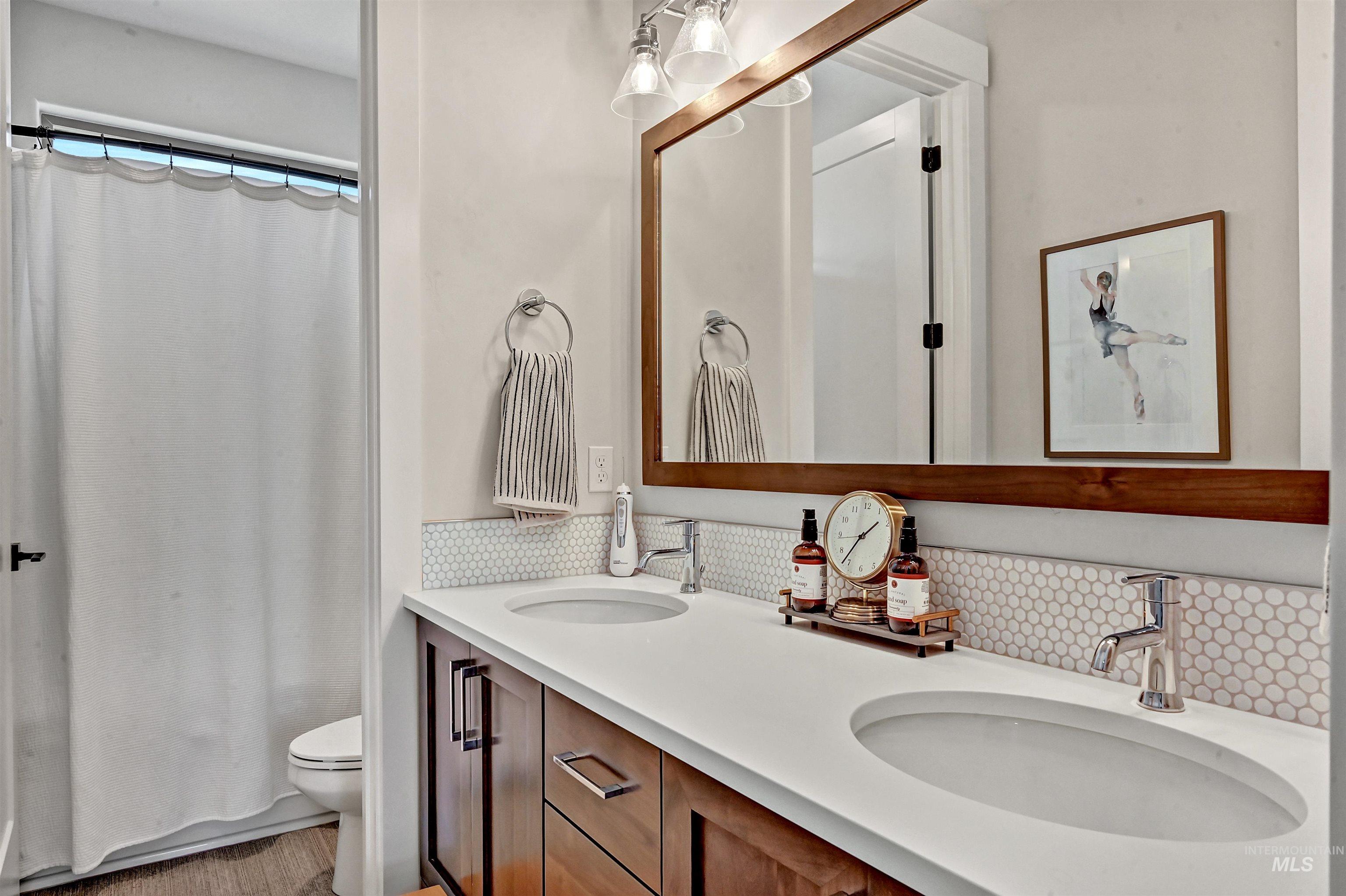Bathroom with double vanity and decorative backsplash