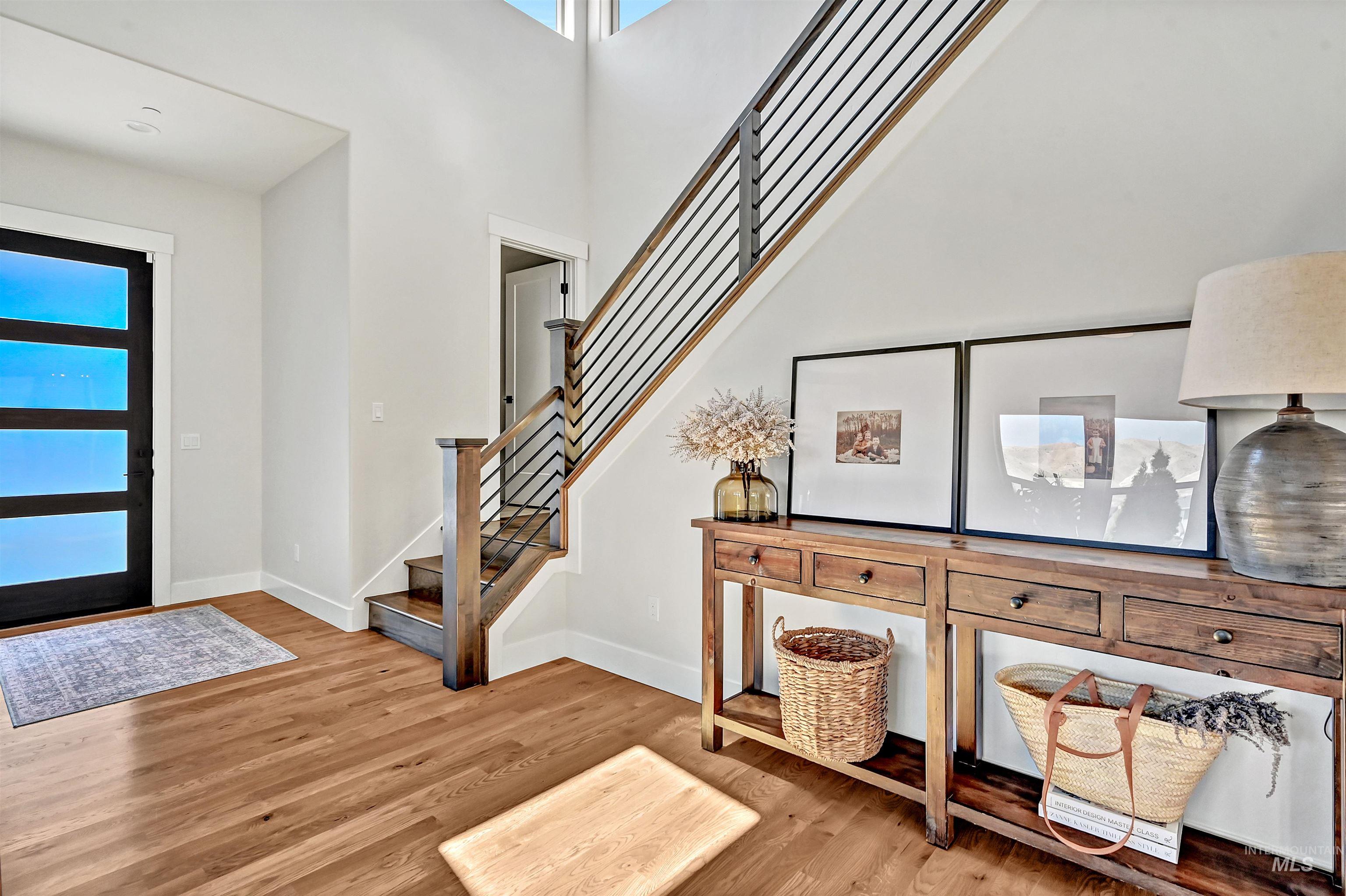 Foyer entrance featuring light wood-style flooring, a high ceiling, and stairs