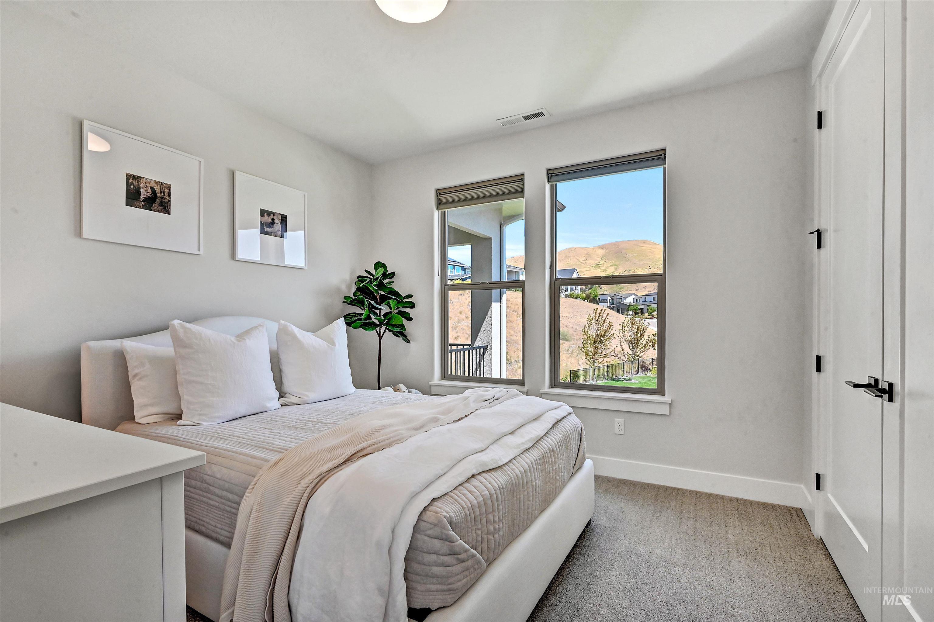 Bedroom with baseboards and light carpet