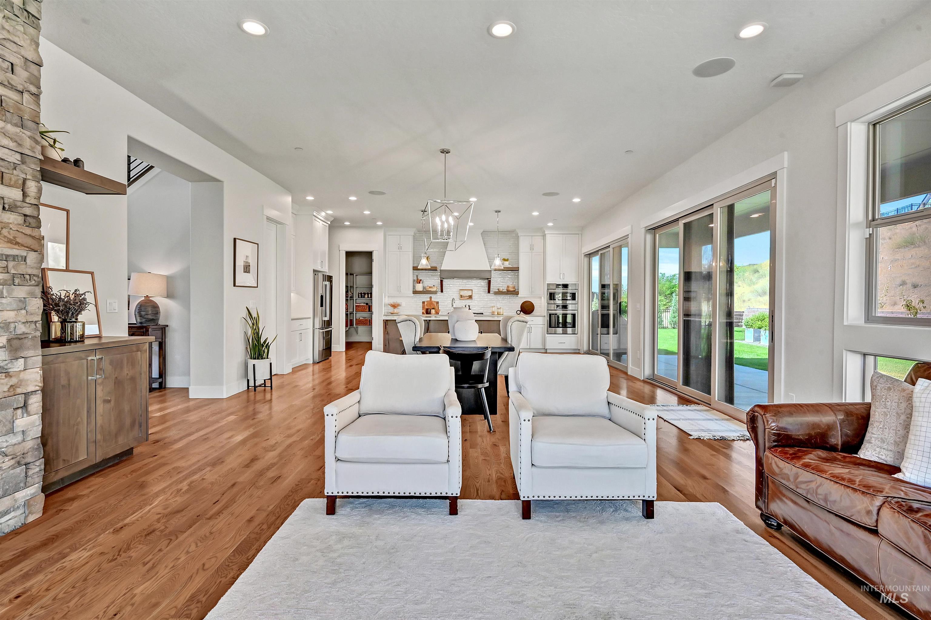 Living room with light wood finished floors, recessed lighting, and a chandelier