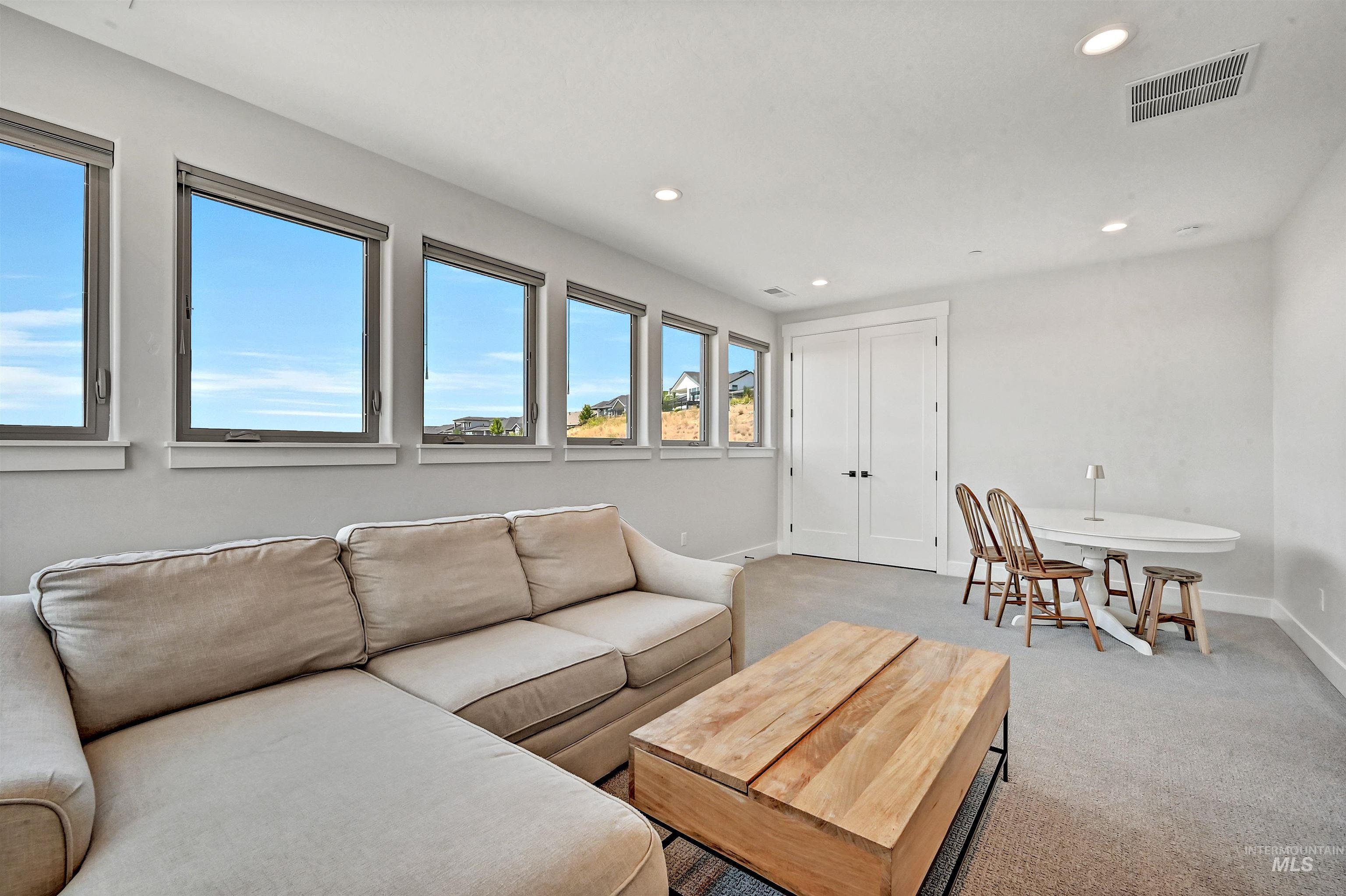 Living area featuring light carpet and recessed lighting
