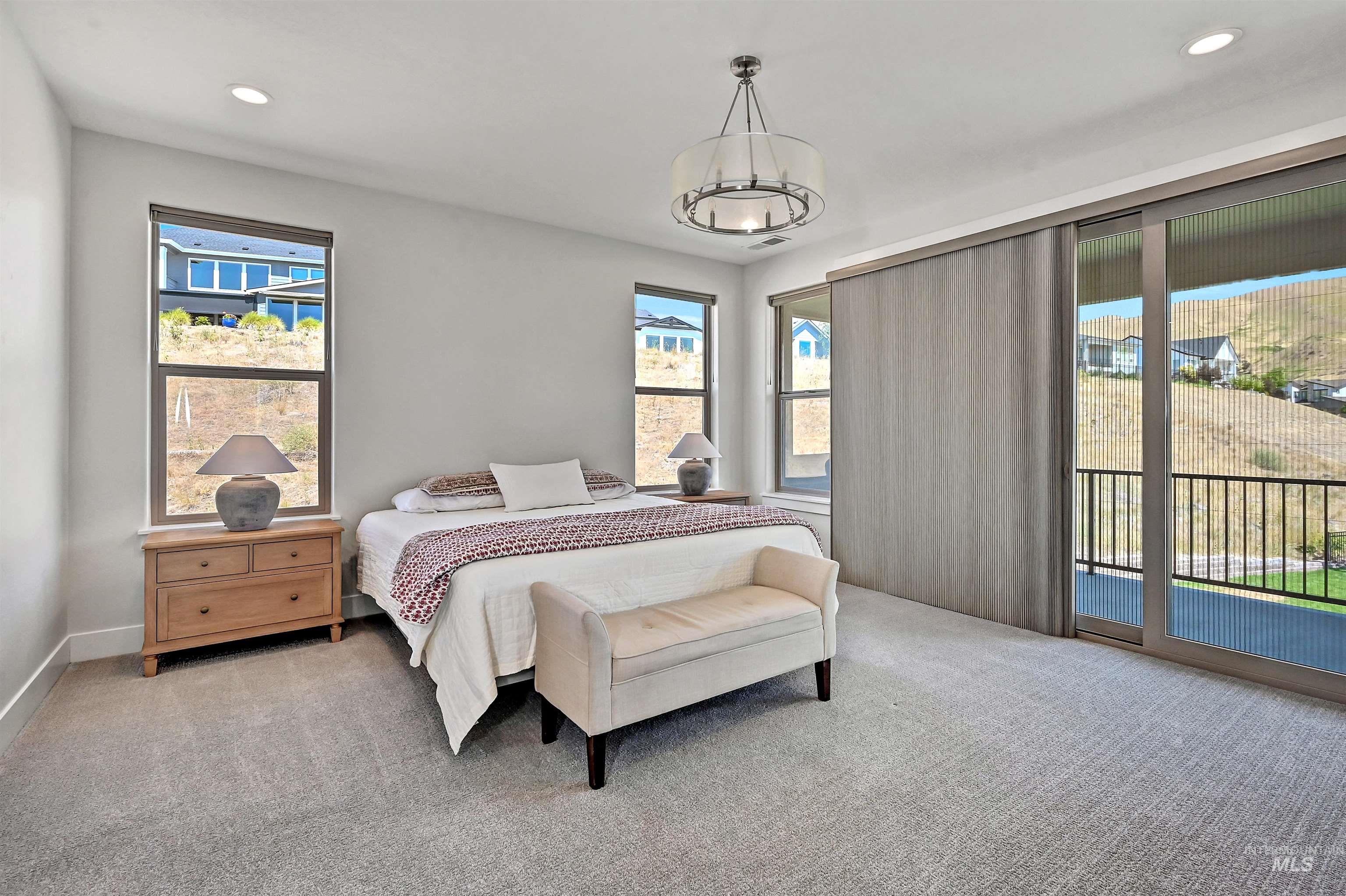 Carpeted bedroom featuring recessed lighting, access to exterior, and a chandelier