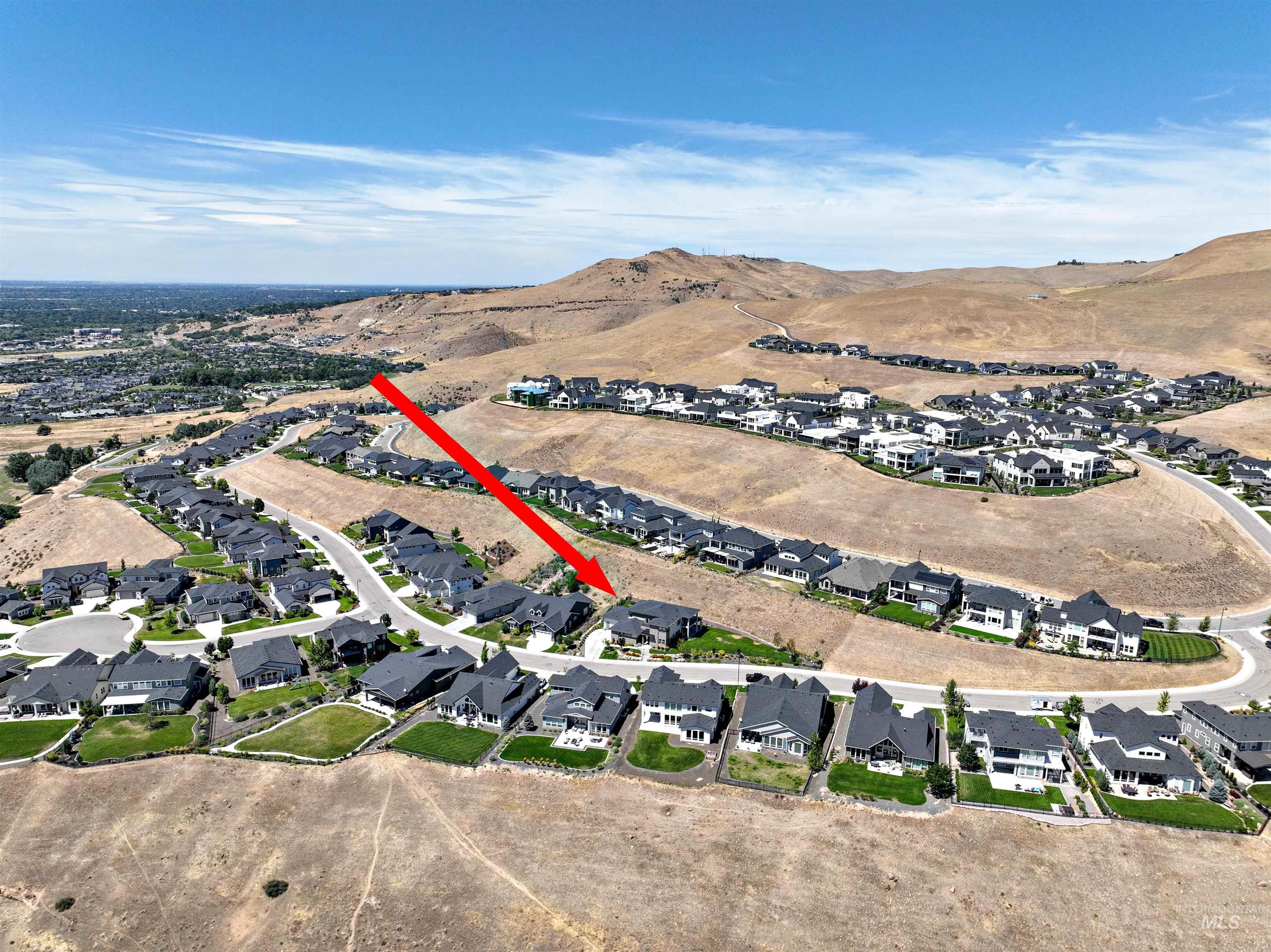 Aerial overview of property's location featuring nearby suburban area and a mountain backdrop