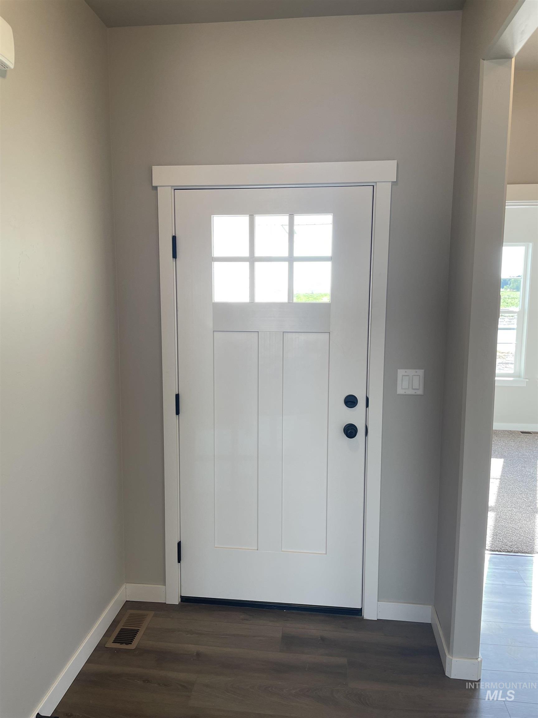 Foyer entrance with baseboards and dark wood-style floors