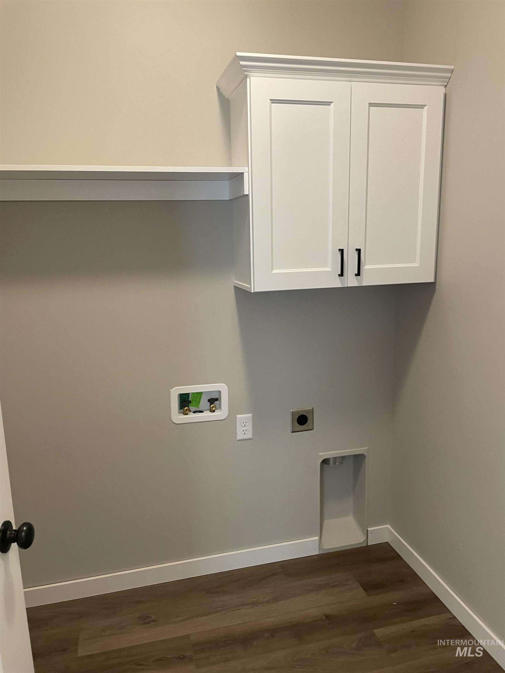 Laundry area featuring hookup for an electric dryer, dark wood-style floors, cabinet space, and washer hookup