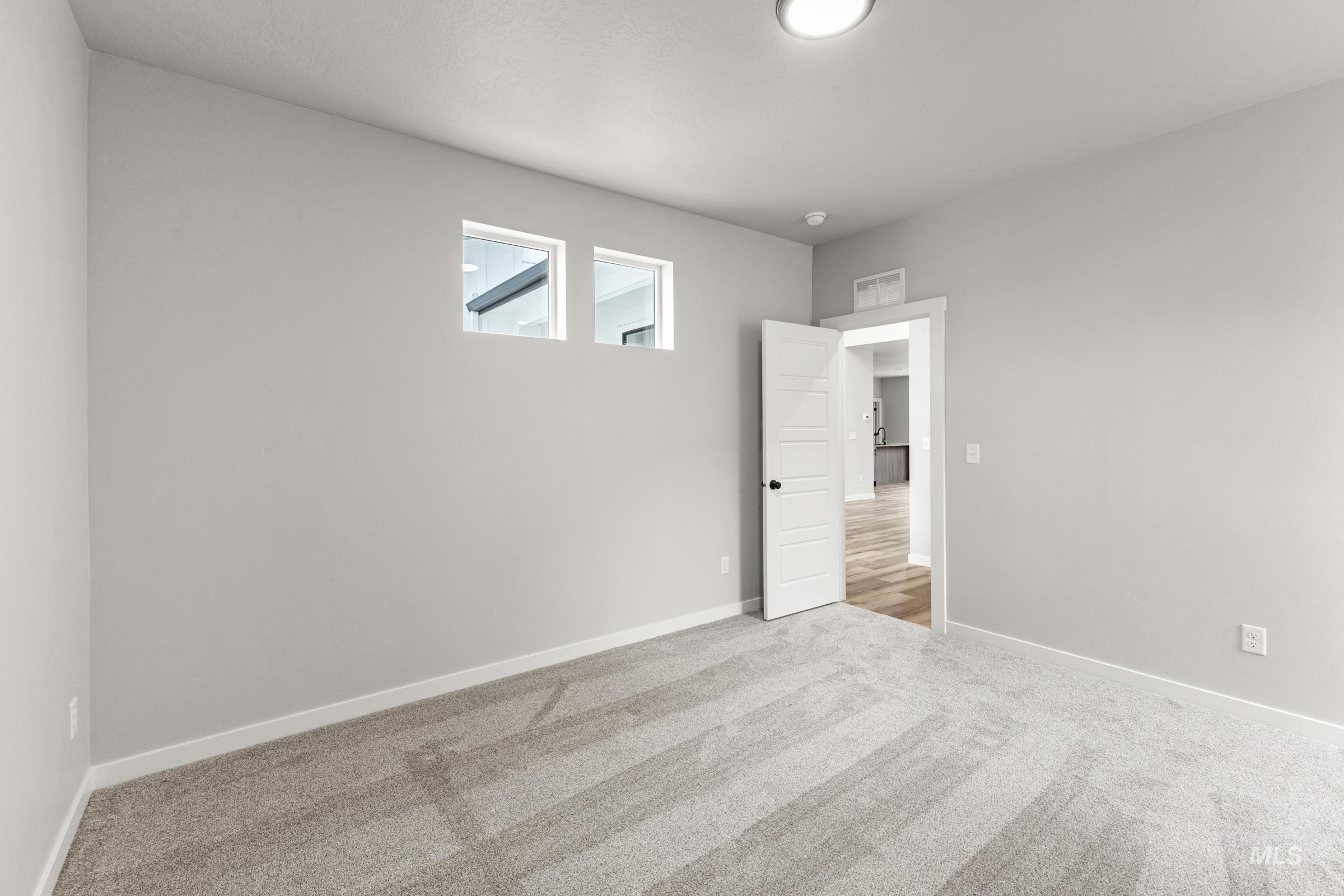 Carpeted empty room featuring baseboards
