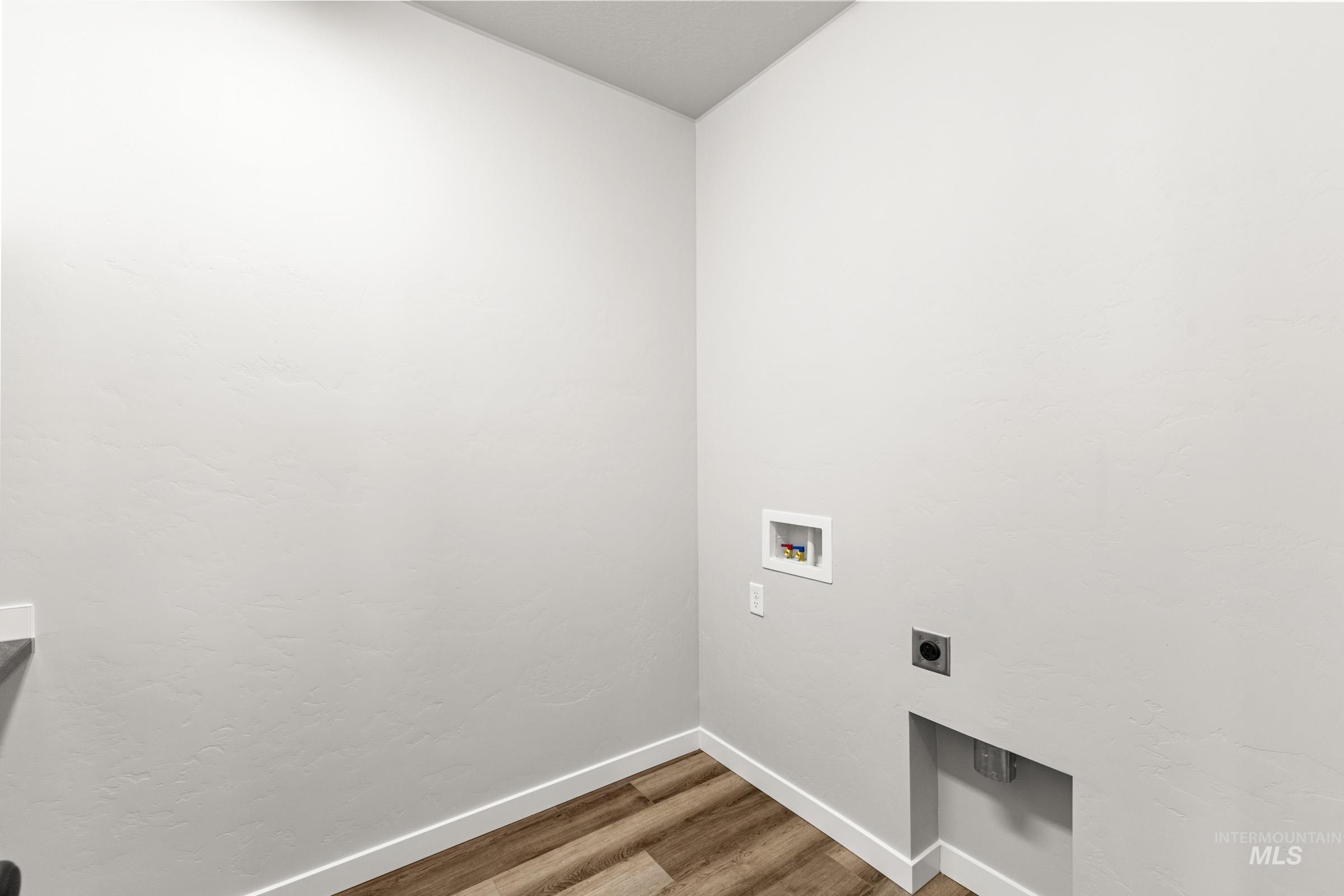 Laundry area featuring wood finished floors, washer hookup, and hookup for an electric dryer