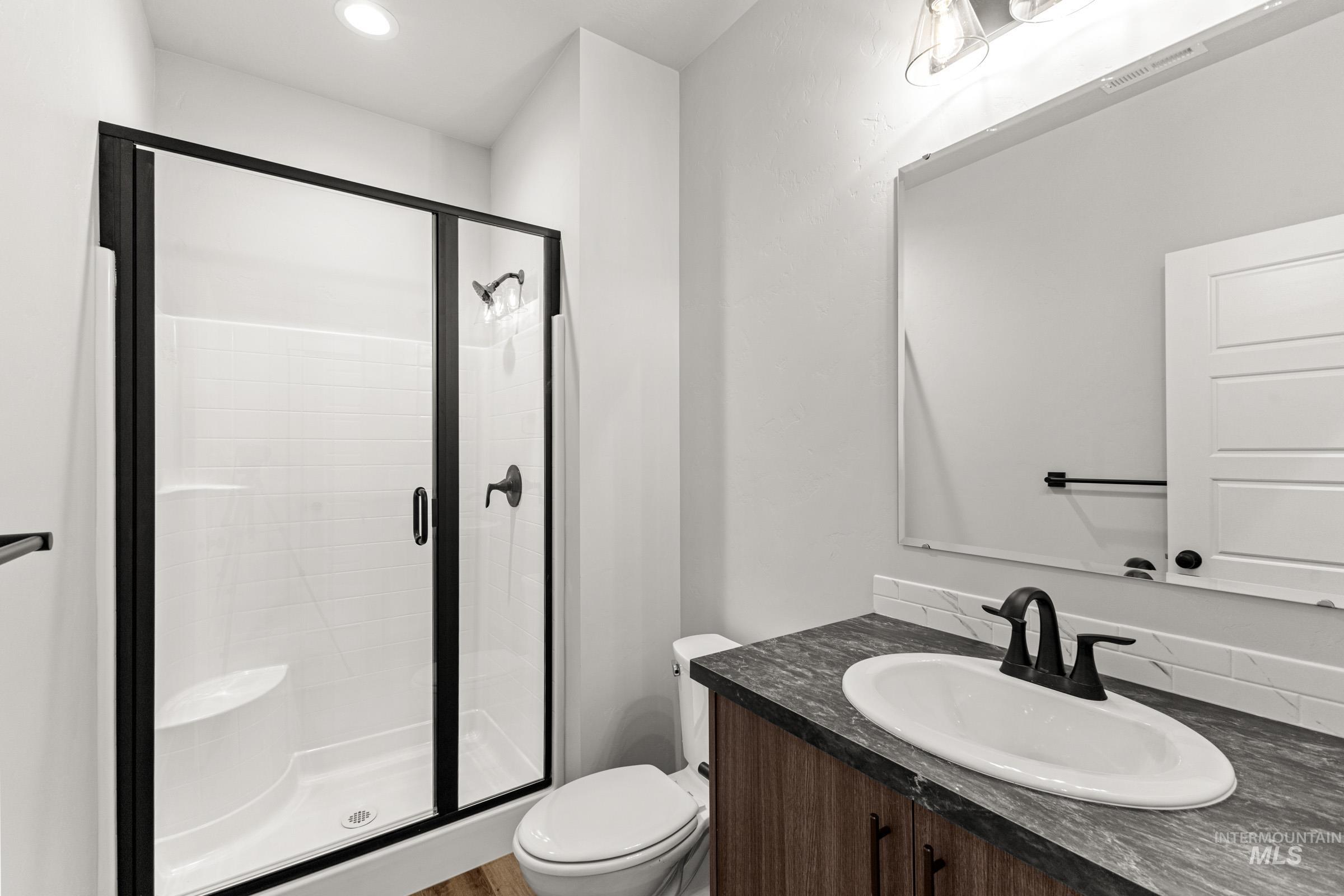 Full bath featuring vanity, a shower stall, and recessed lighting