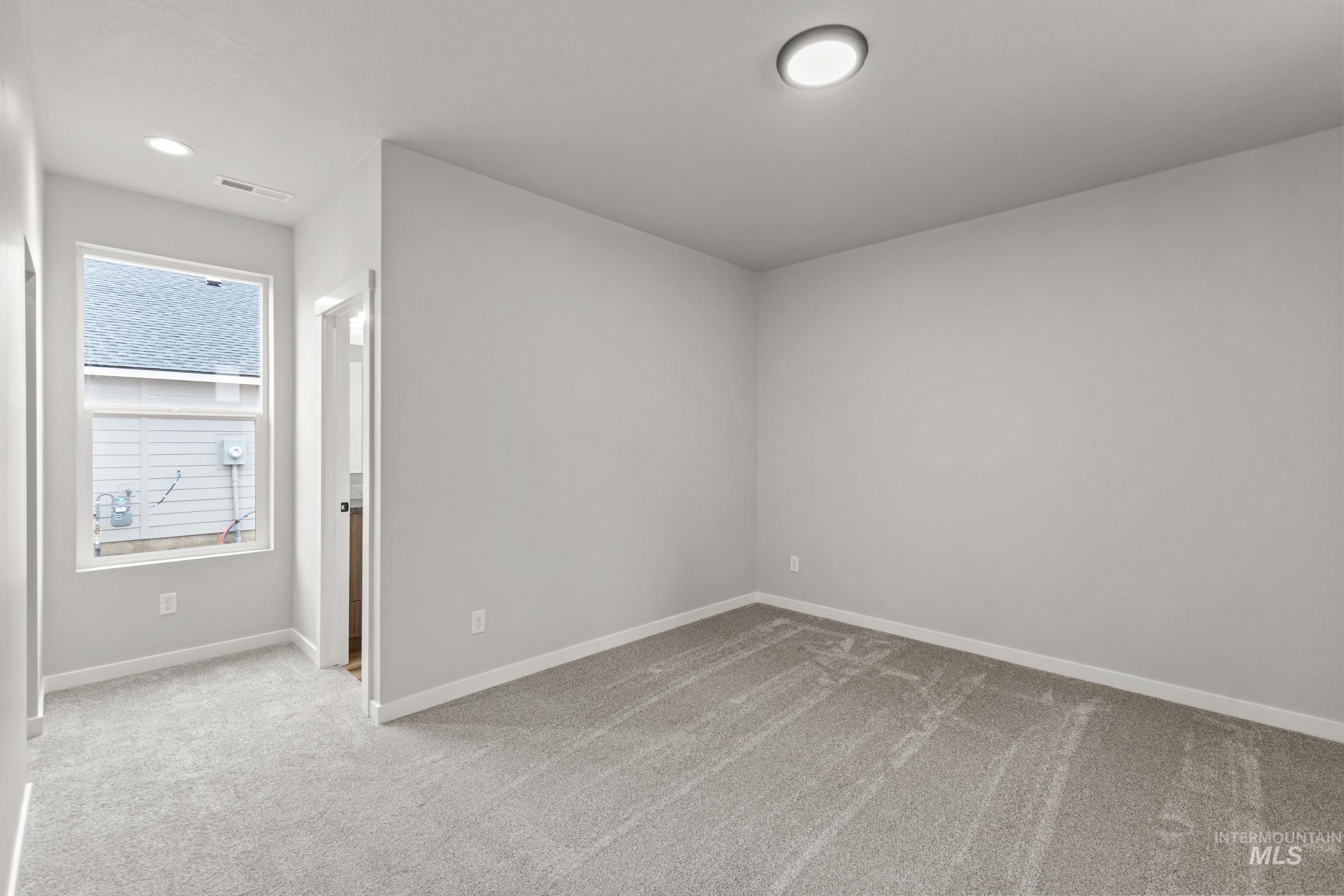 Unfurnished bedroom with light carpet and recessed lighting