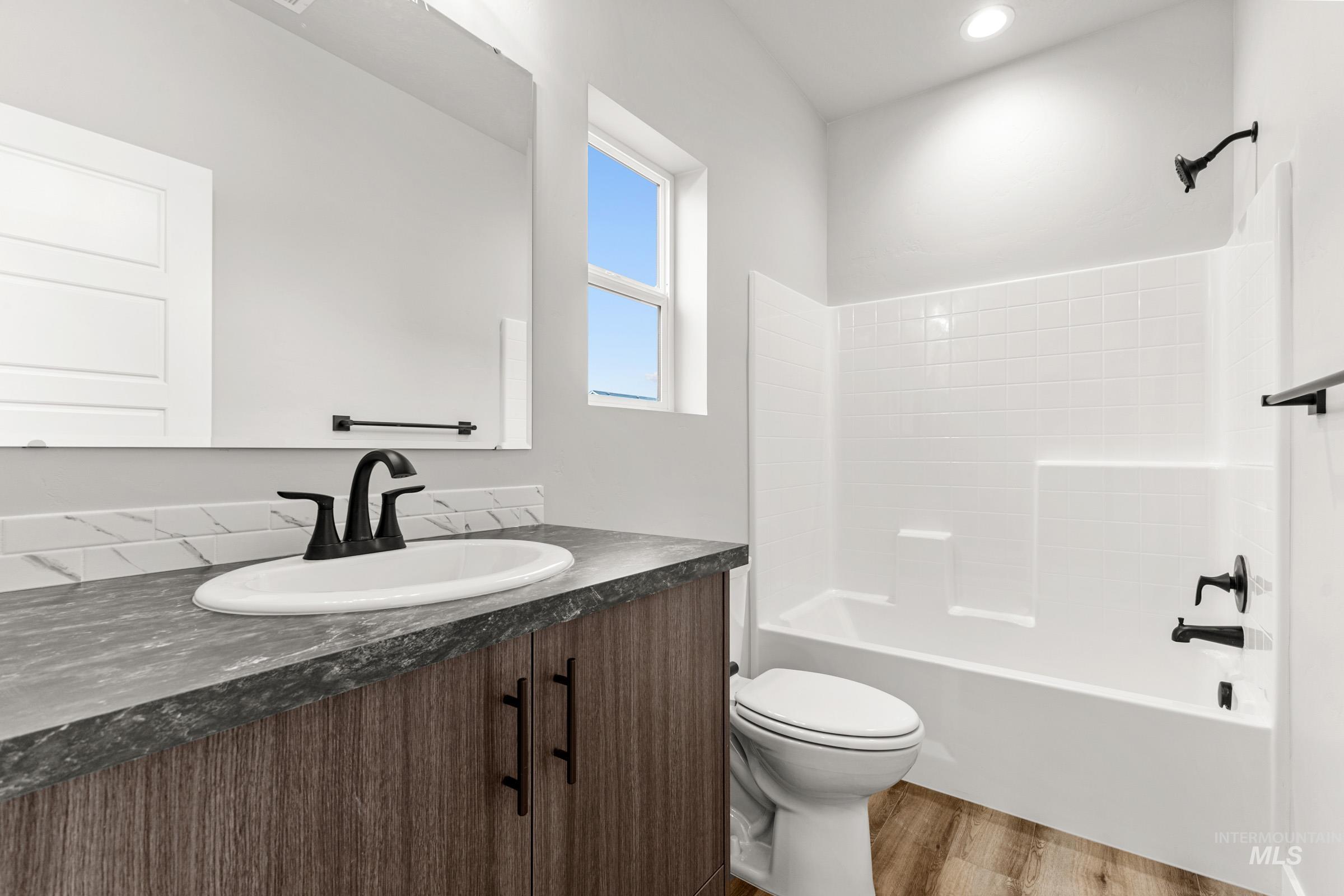 Bathroom featuring vanity, light wood-style floors, and shower / bath combination