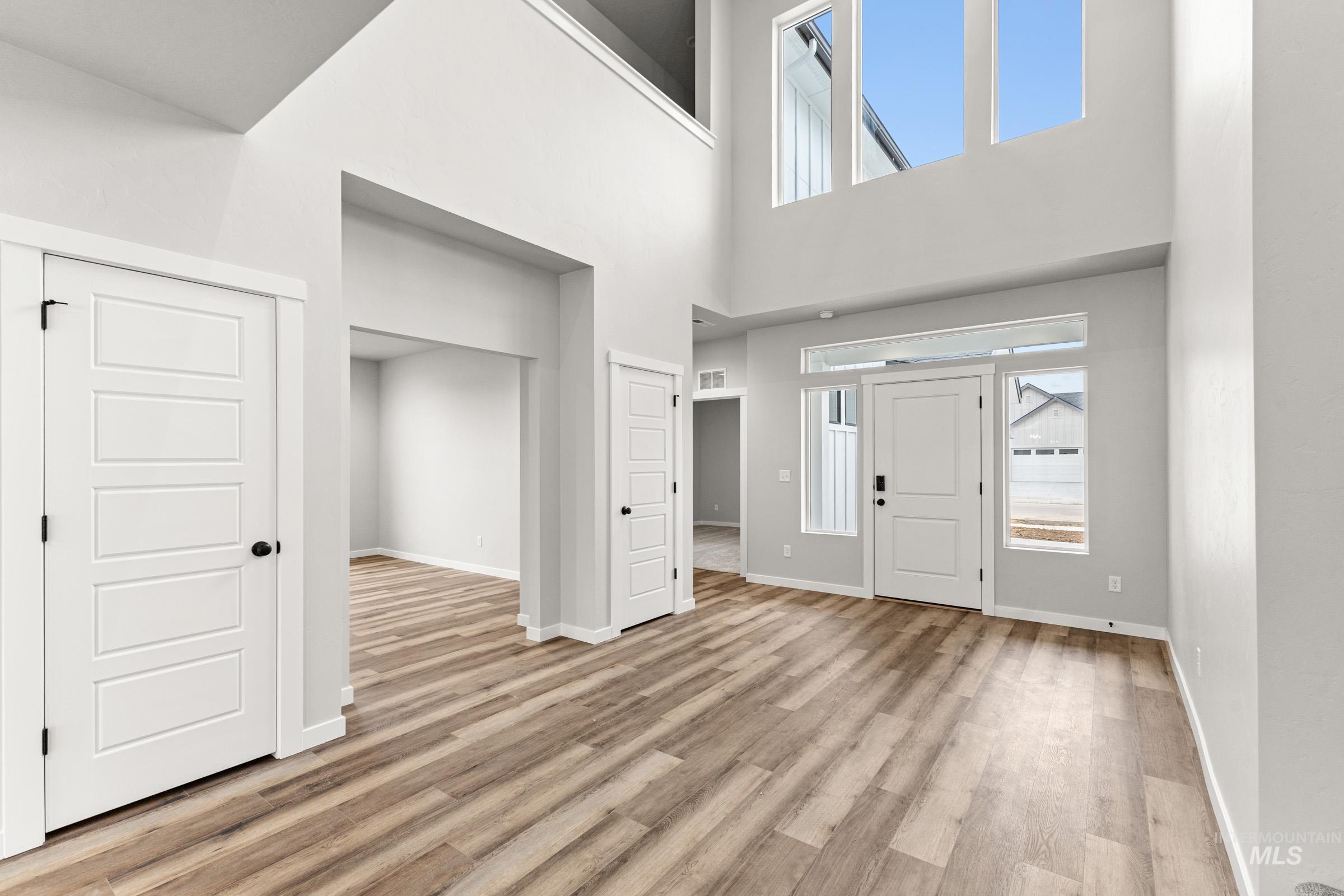 Entryway with light wood-style floors and a high ceiling