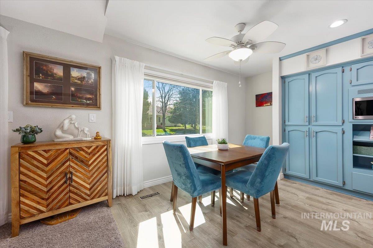 Dining area with ceiling fan and light wood finished floors
