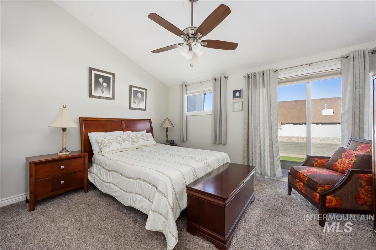 Carpeted bedroom featuring lofted ceiling and ceiling fan