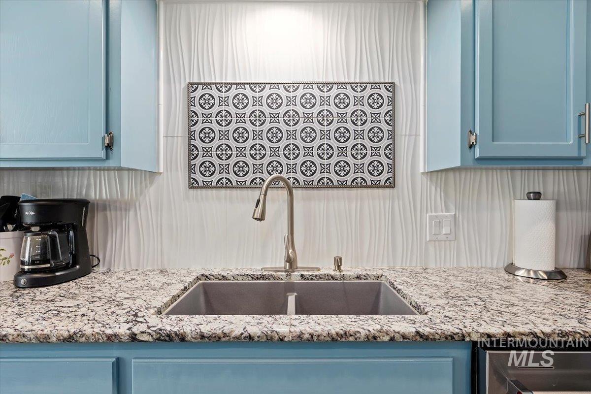Kitchen featuring blue cabinetry and light stone counters