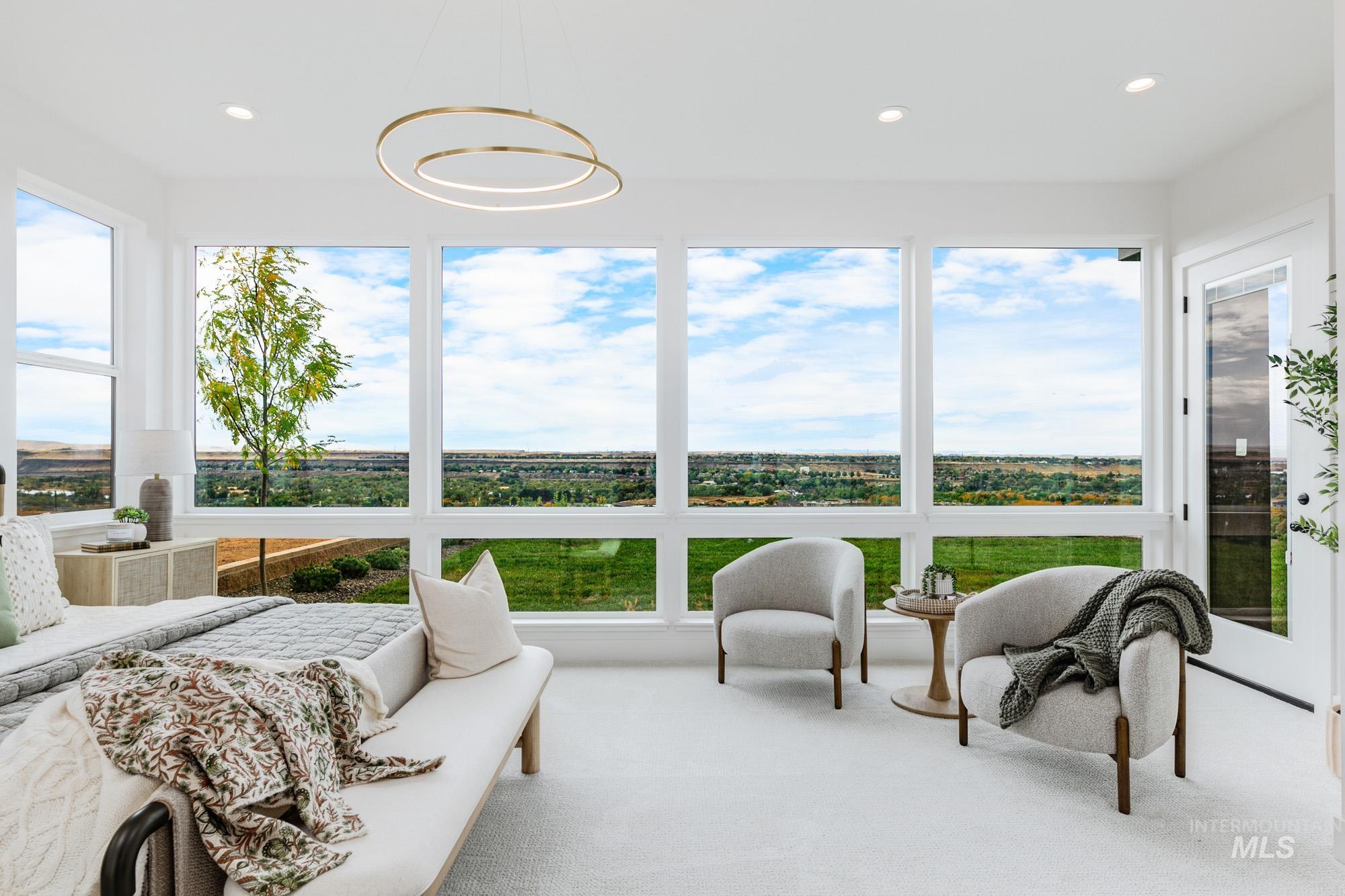 Spacious room with expansive window wall, recessed lighting, and a modern circular pendant light fixture
