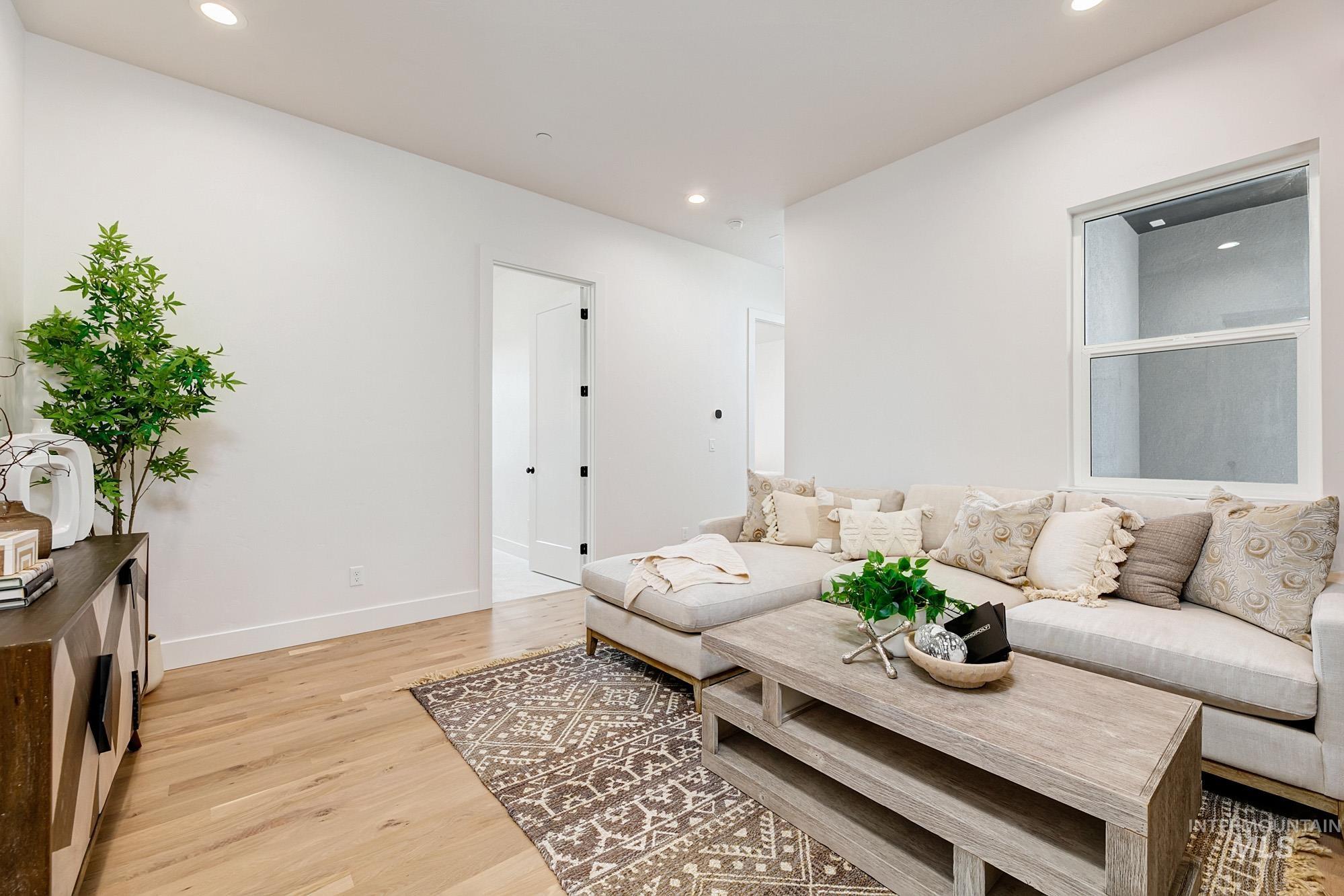 Living area featuring recessed lighting, wood-finish flooring, and a large window