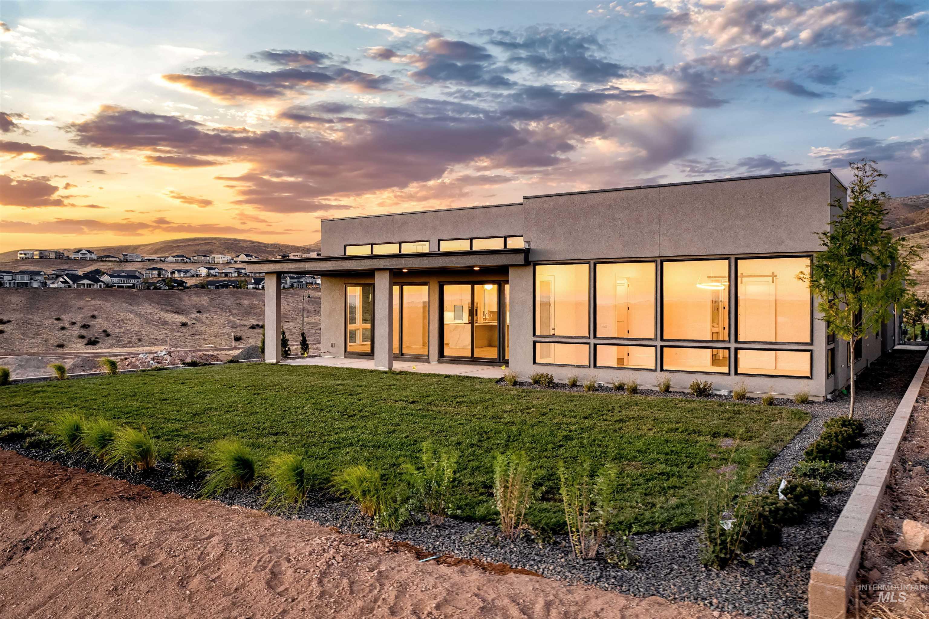 Modern stucco exterior featuring expansive windows and a covered patio