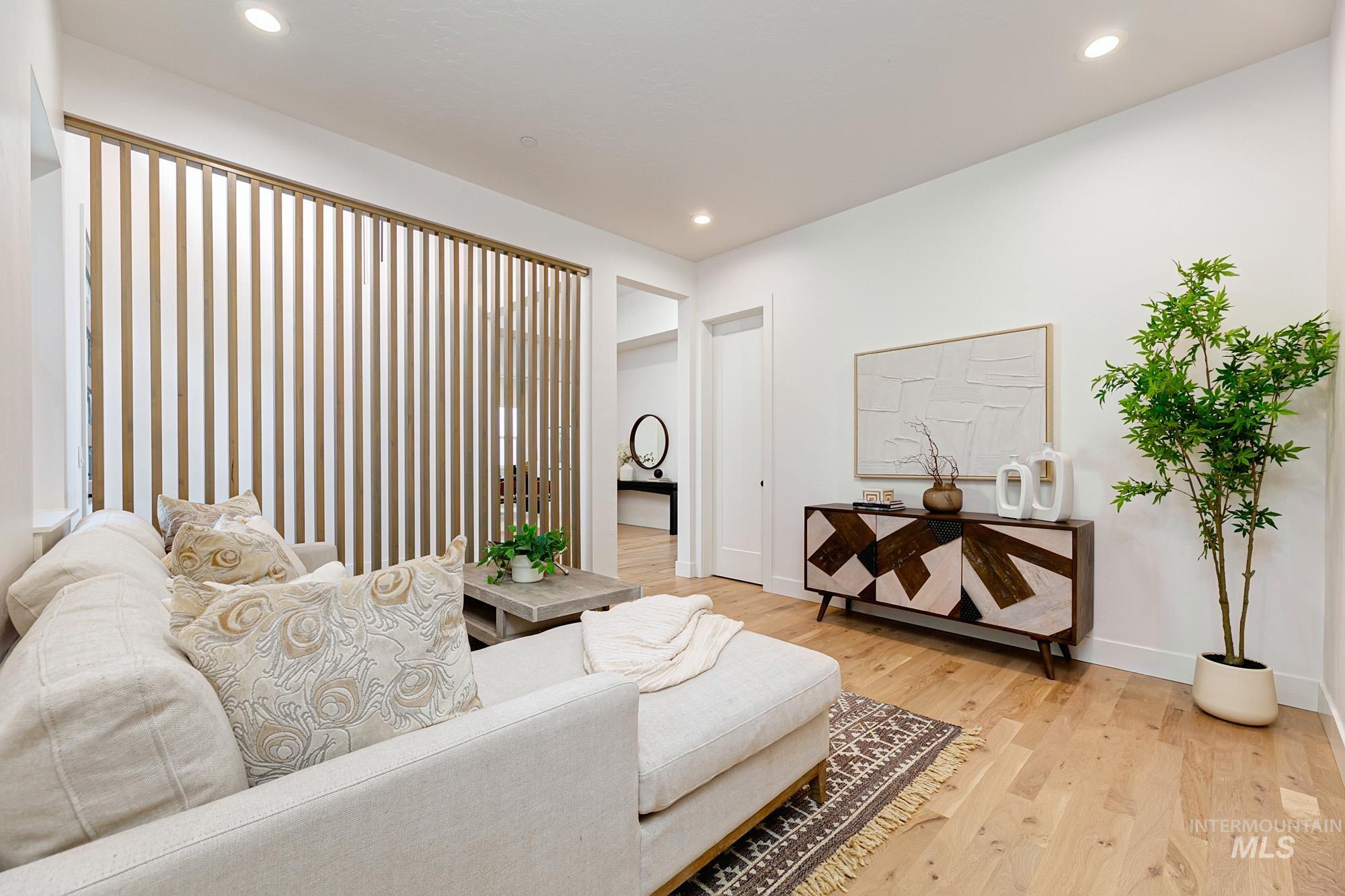 Light wood-finish flooring complements the white walls and recessed lighting
