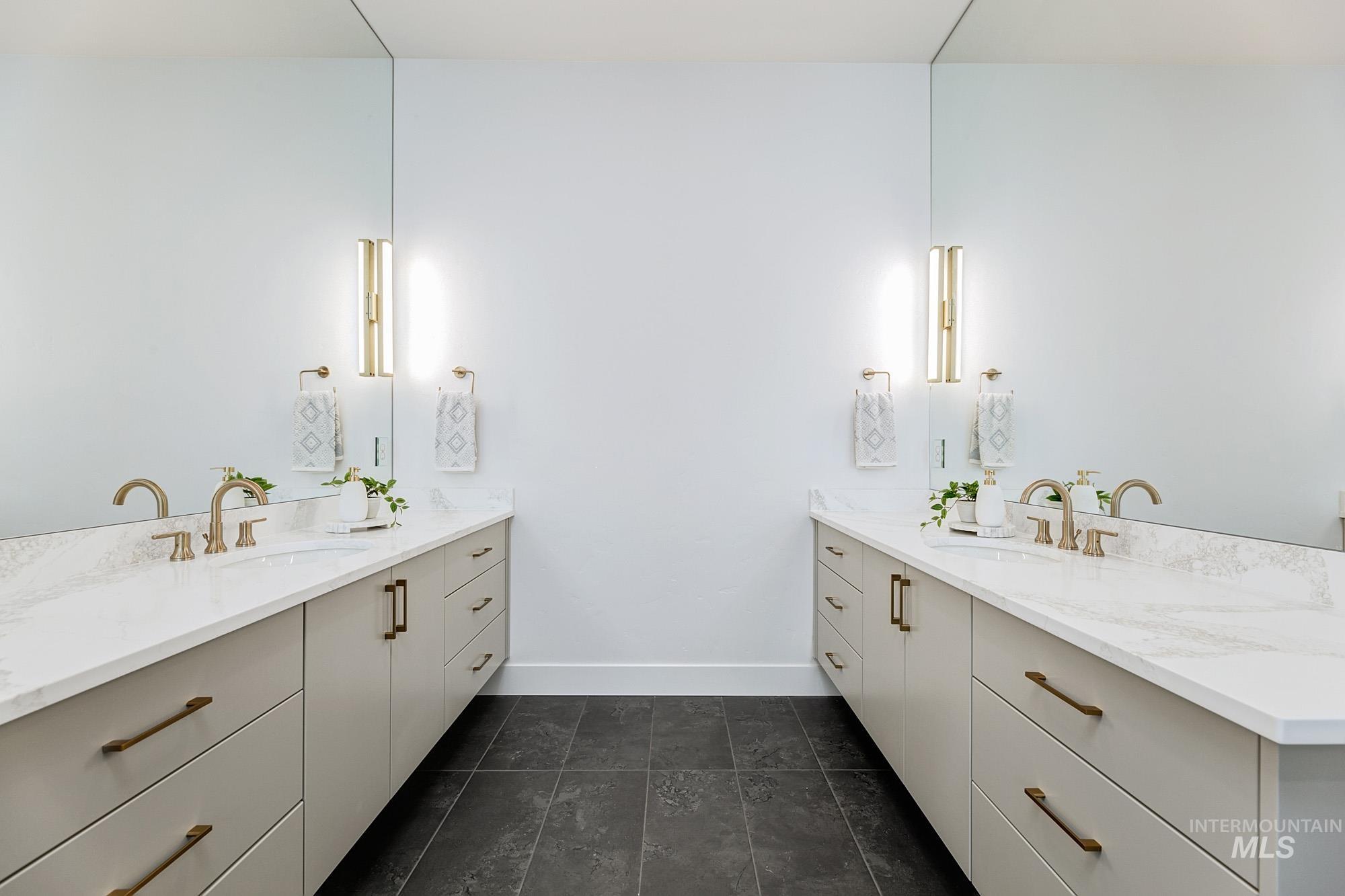 Dual floating vanities featuring stone-finish countertops and integrated sinks