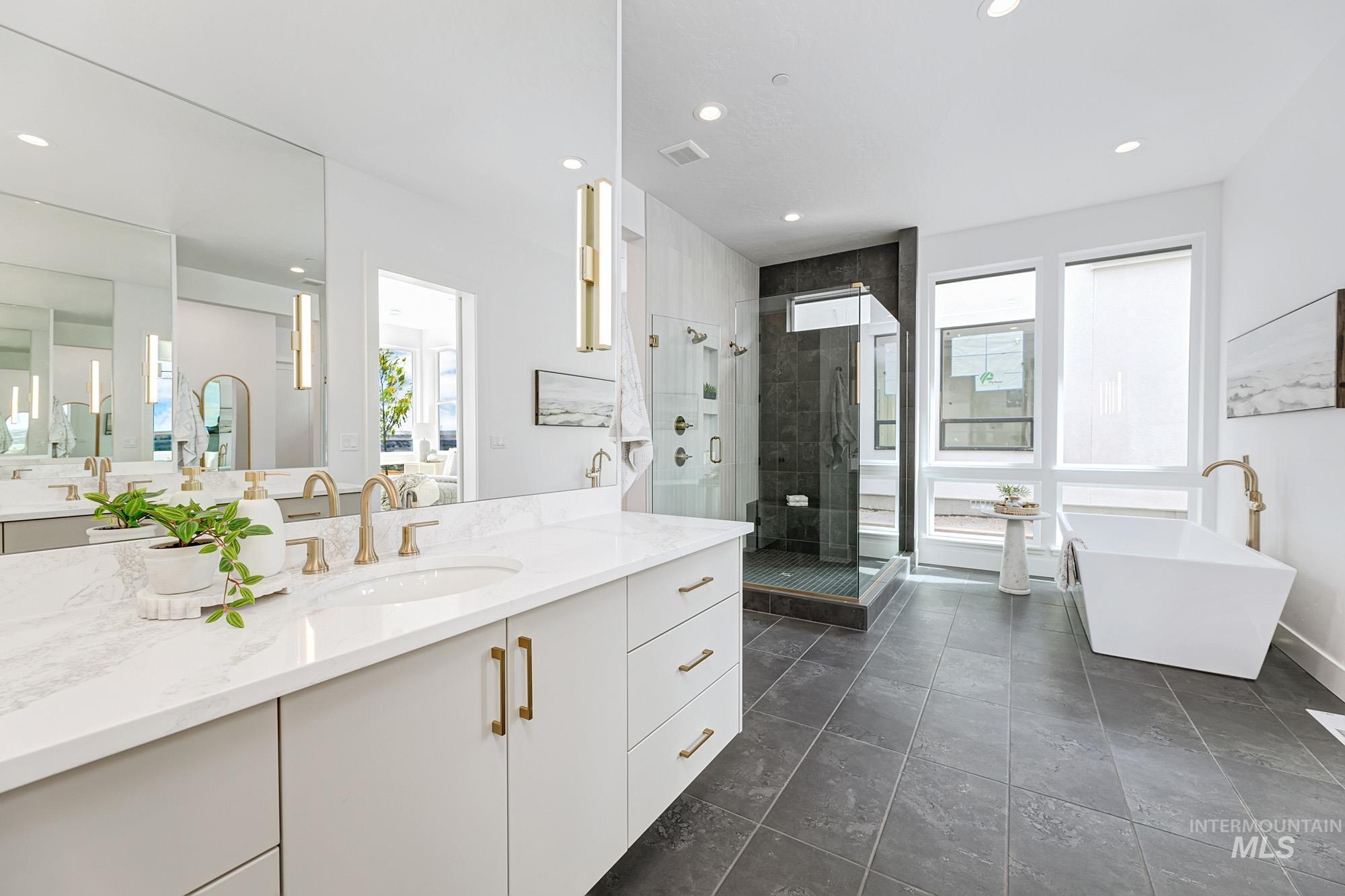 Contemporary bathroom featuring a dual vanity with light-colored cabinetry and stone-finish countertops