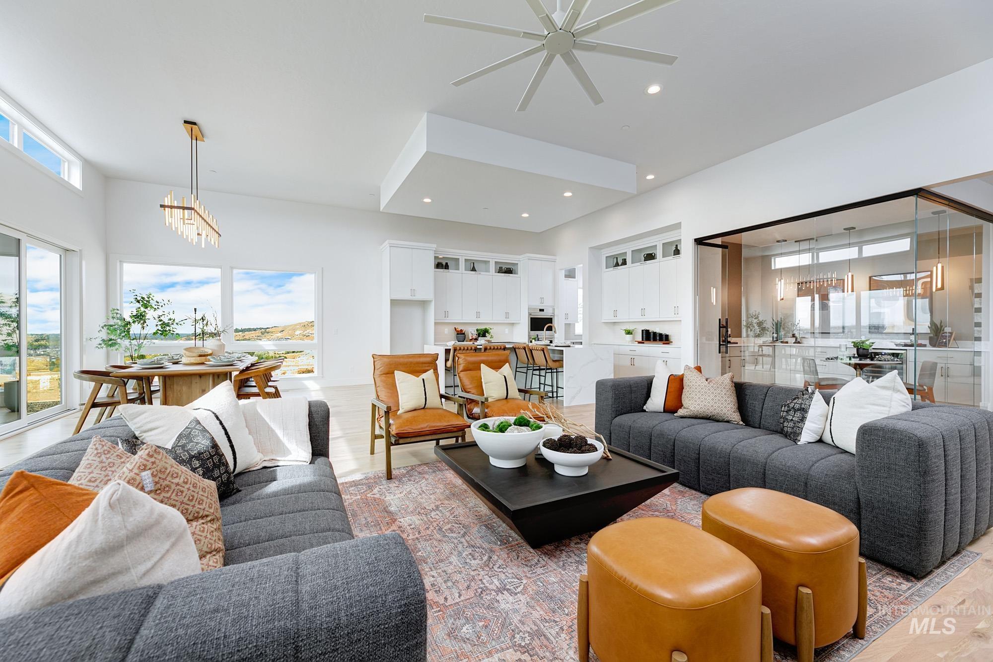 Open-concept living area featuring high ceilings, wood-finish flooring, and large windows