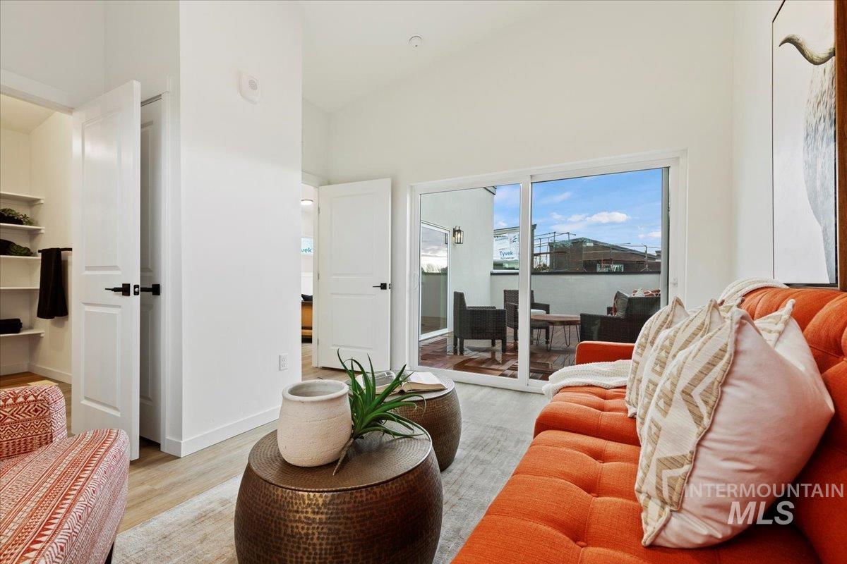 Living area featuring wood finished floors and a towering ceiling