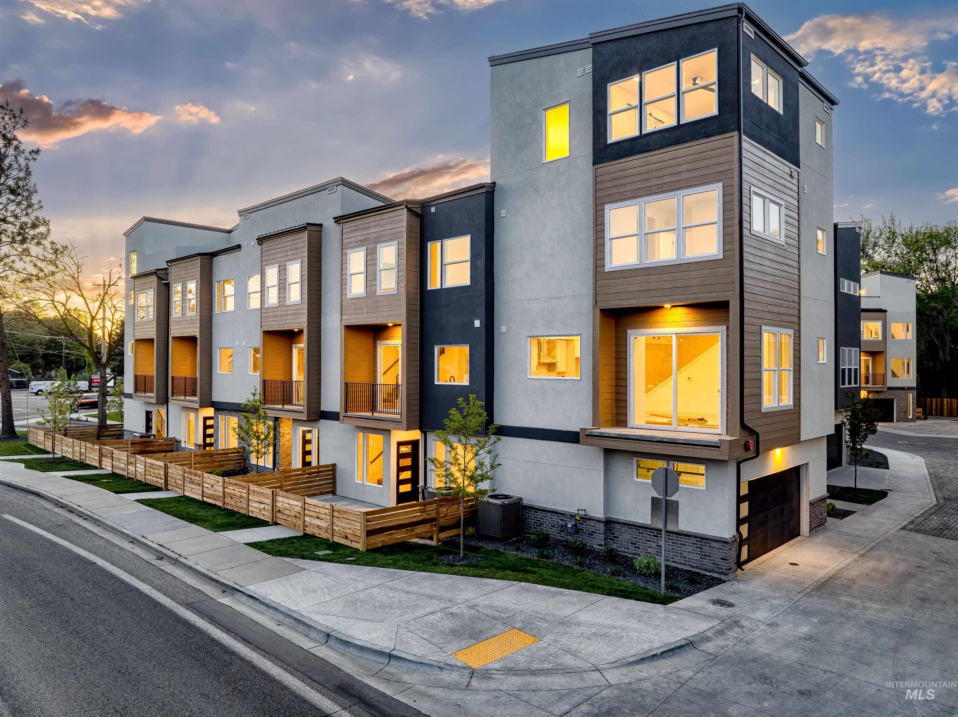 Modern home featuring stucco siding, a residential view, a garage, and concrete driveway