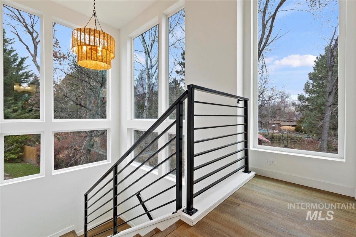 Stairway with plenty of natural light and wood finished floors