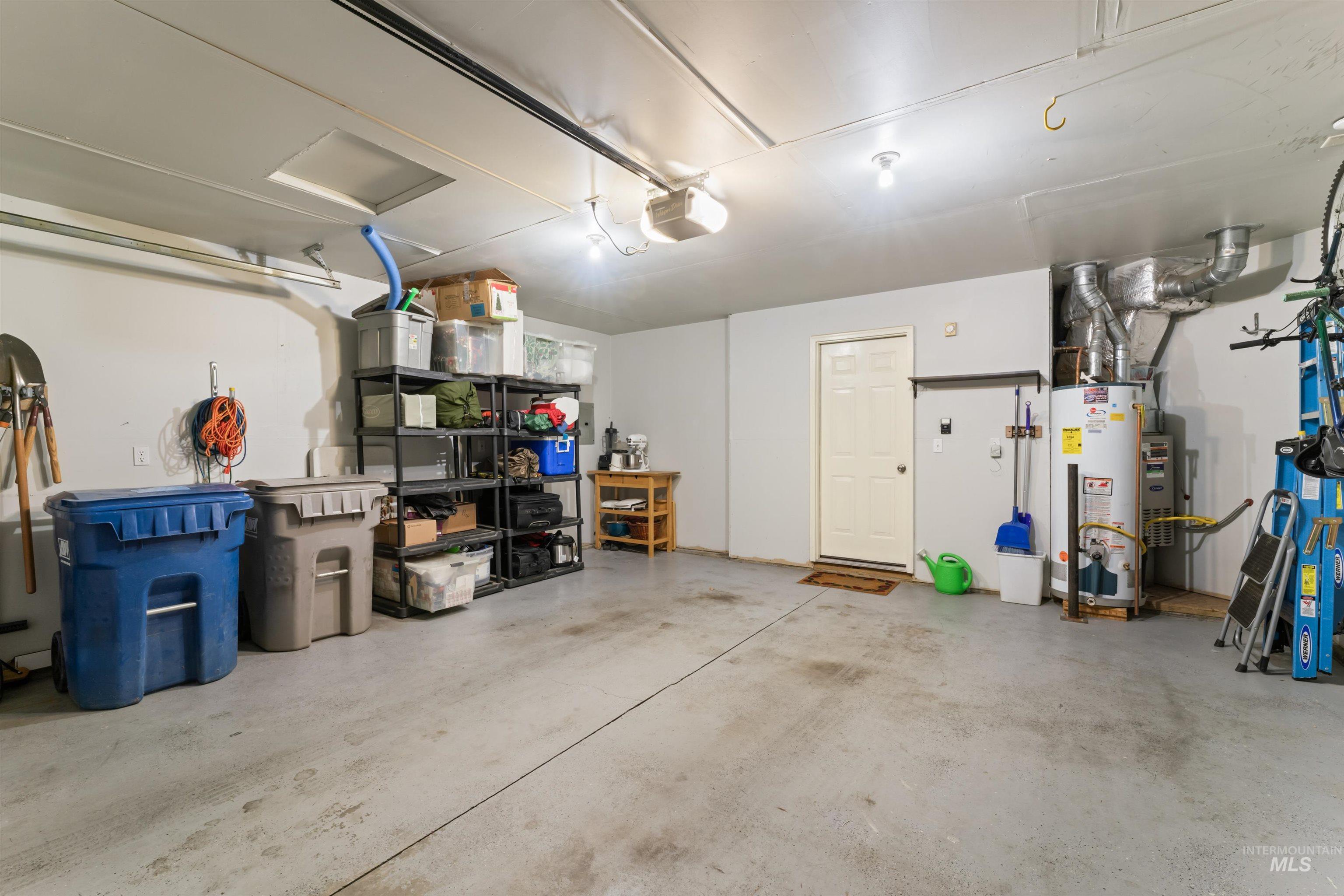 Garage featuring gas water heater and a garage door opener