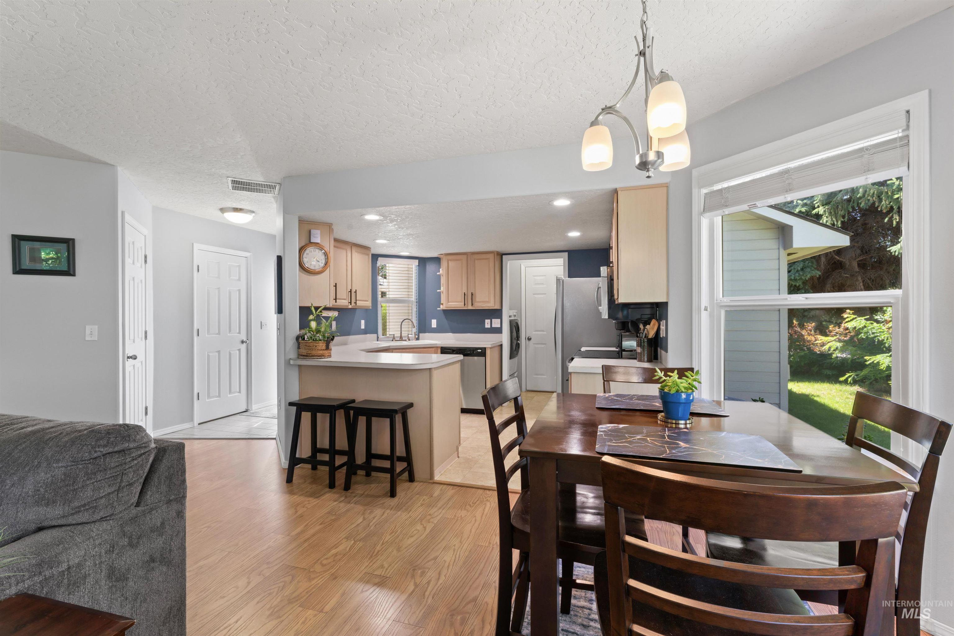 Dining space featuring a textured ceiling, light wood-type flooring, and recessed lighting