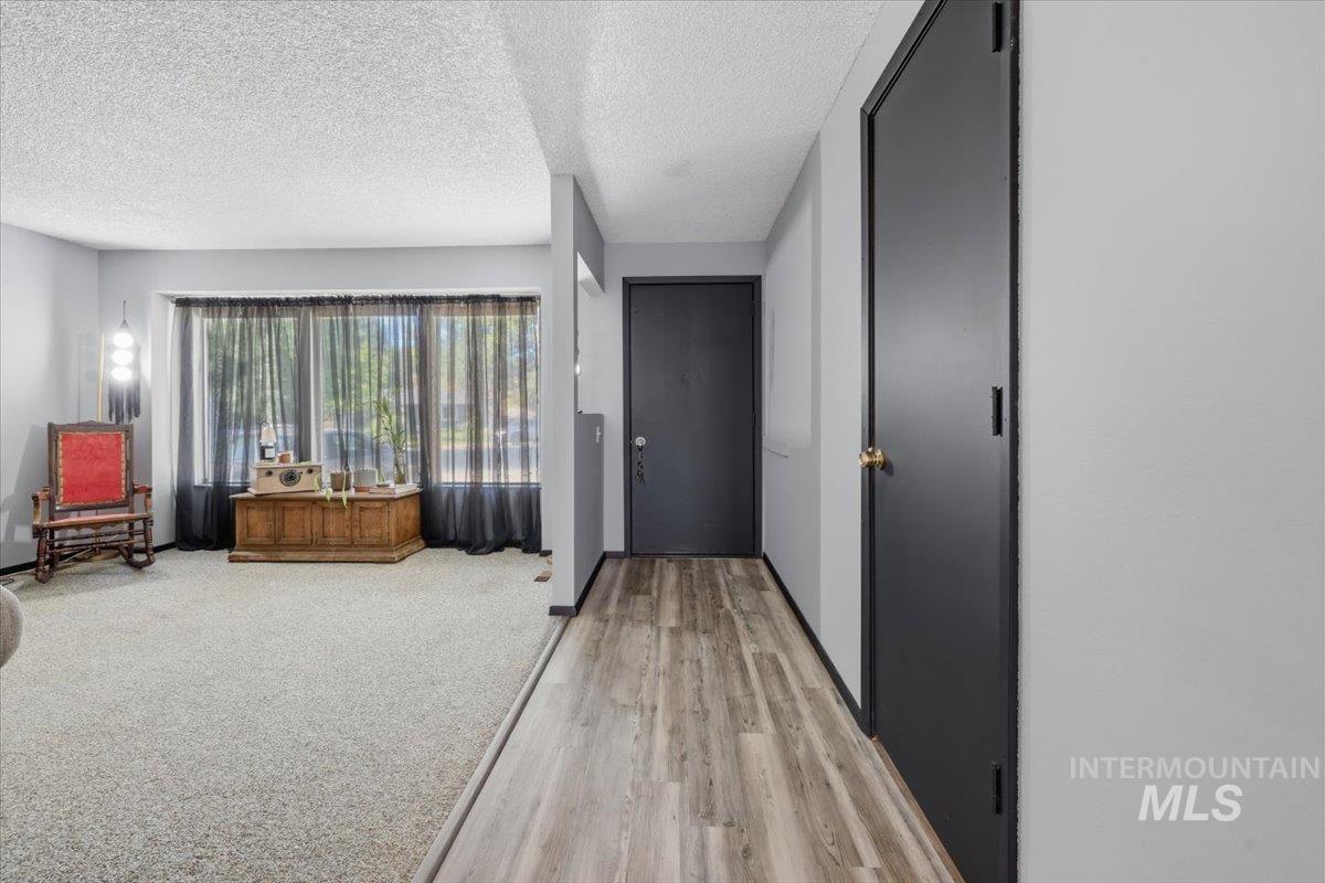Entryway featuring wood-finish flooring, a dark entry door, and light gray walls