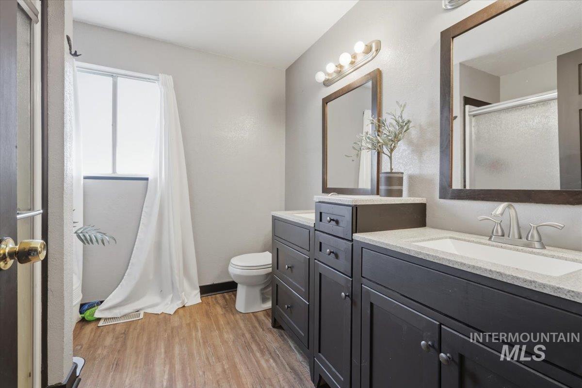Bathroom featuring a dual vanity with dark wood cabinetry, white countertops, and undermount sinks