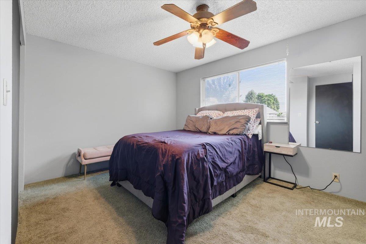 Bedroom featuring light gray walls, carpet flooring, and a ceiling fan with integrated lighting