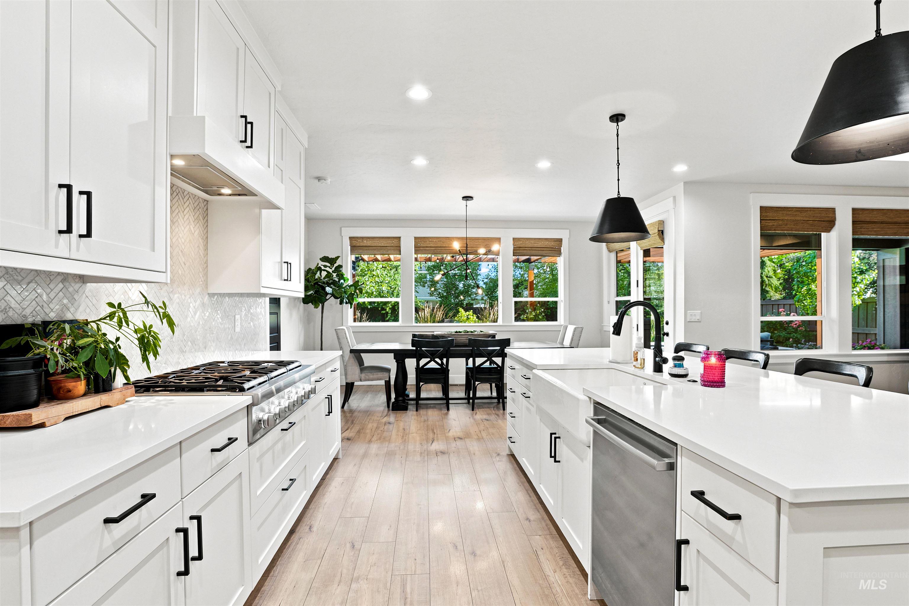 Modern kitchen featuring white cabinetry, light wood-finish flooring, and white countertops