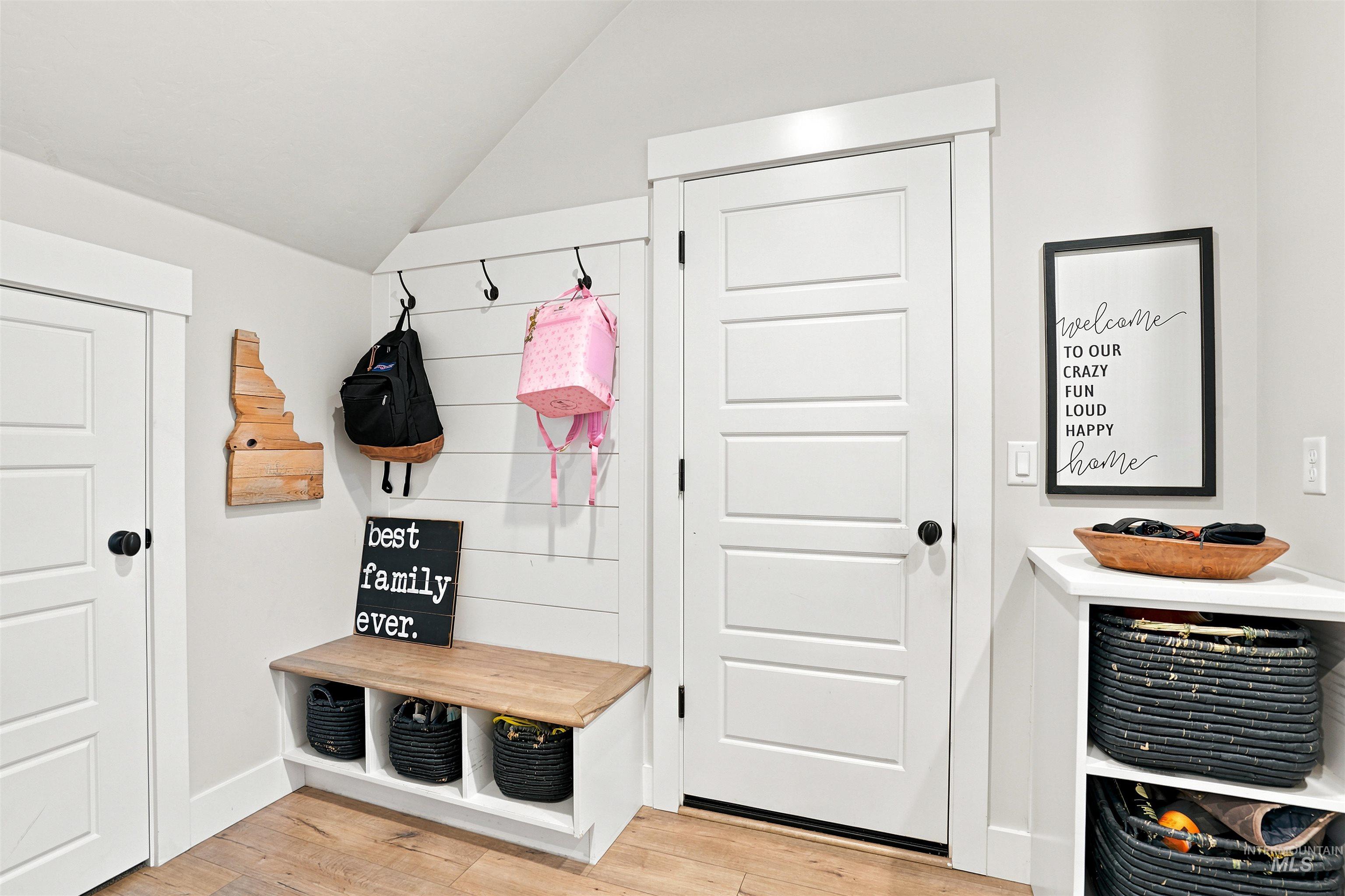 Entryway features a built-in bench with a natural wood-finish top and integrated storage cubbies