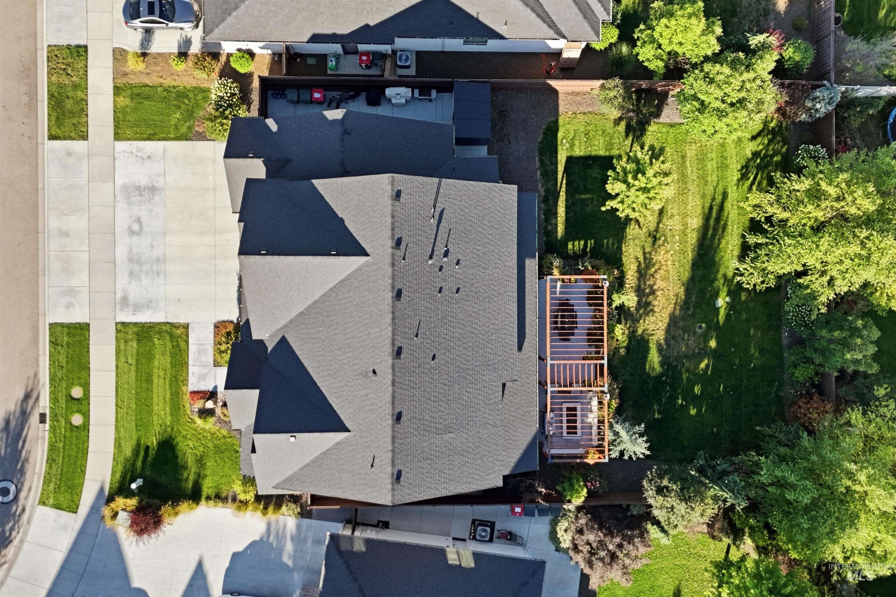 Aerial perspective showcasing a multi-gabled roofline and an extensive backyard