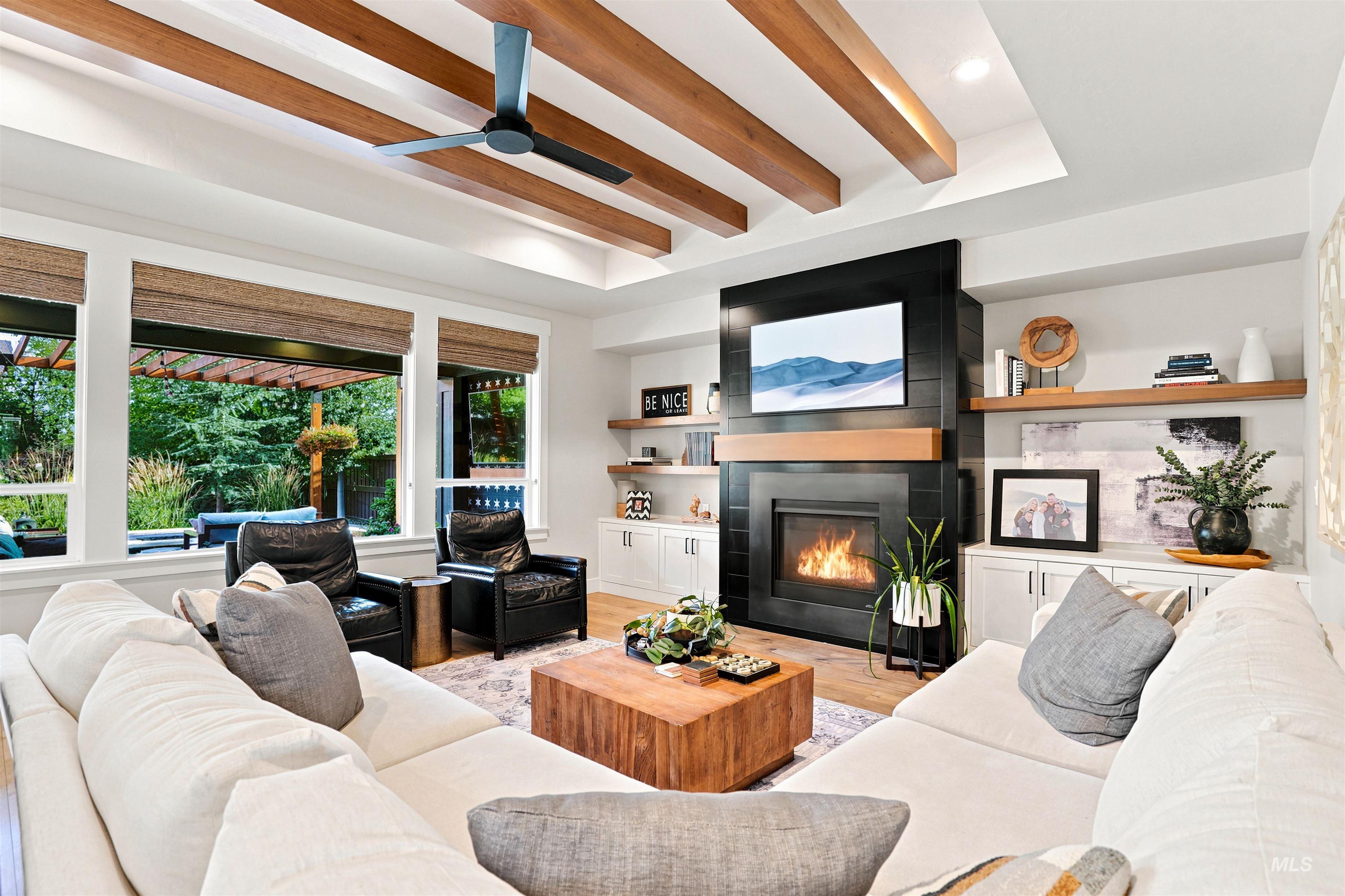 Living area featuring a coffered ceiling with exposed wood beams and a ceiling fan