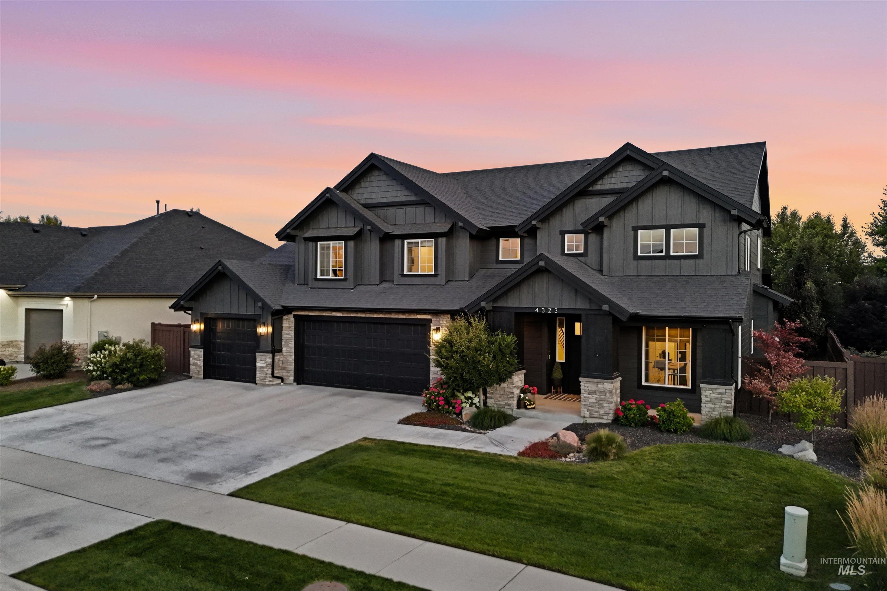 Contemporary two-story exterior featuring dark siding, stone accents, and a multi-gabled roofline