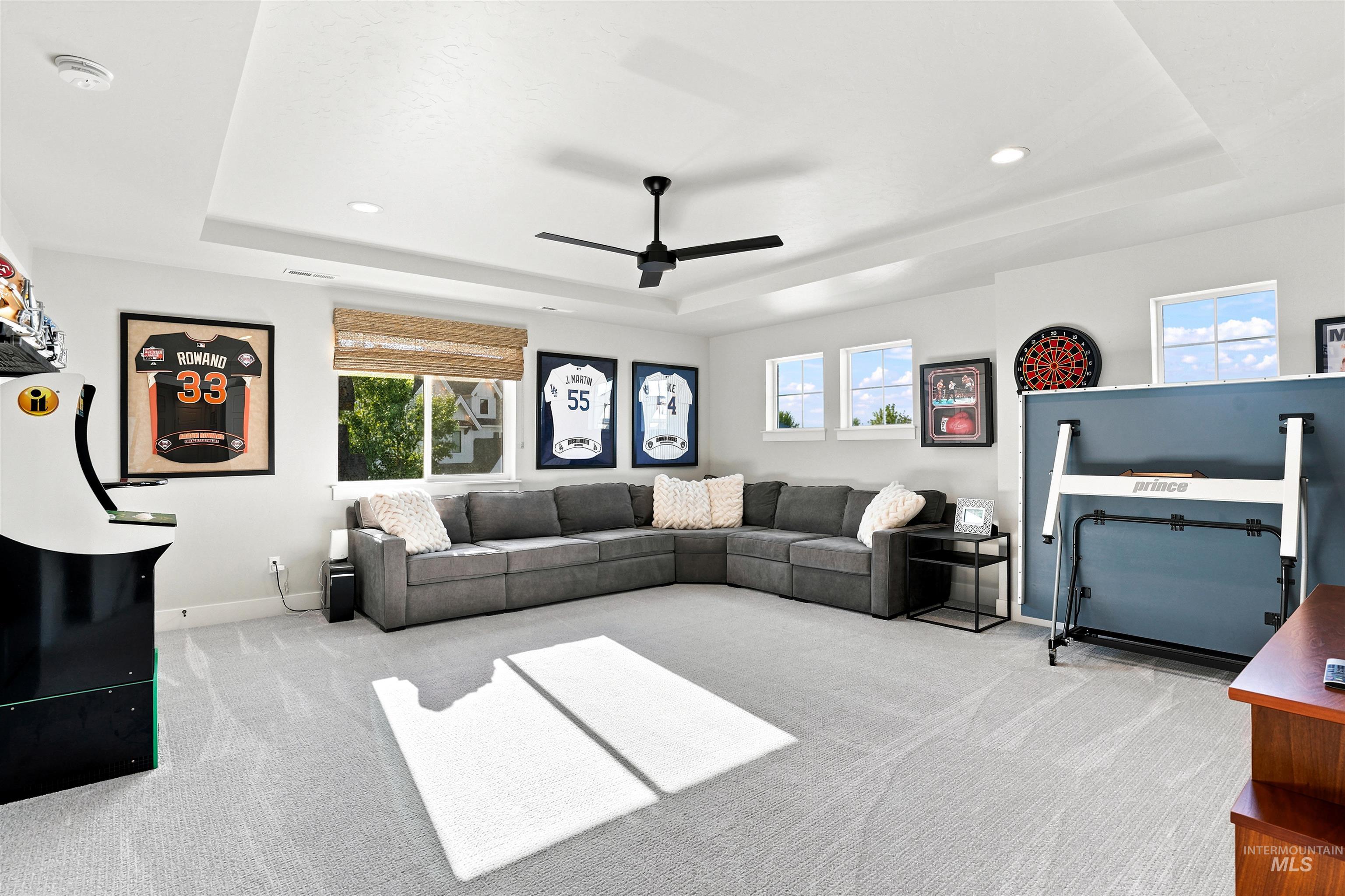 Spacious bonus room featuring a tray ceiling, recessed lighting, and a modern ceiling fan