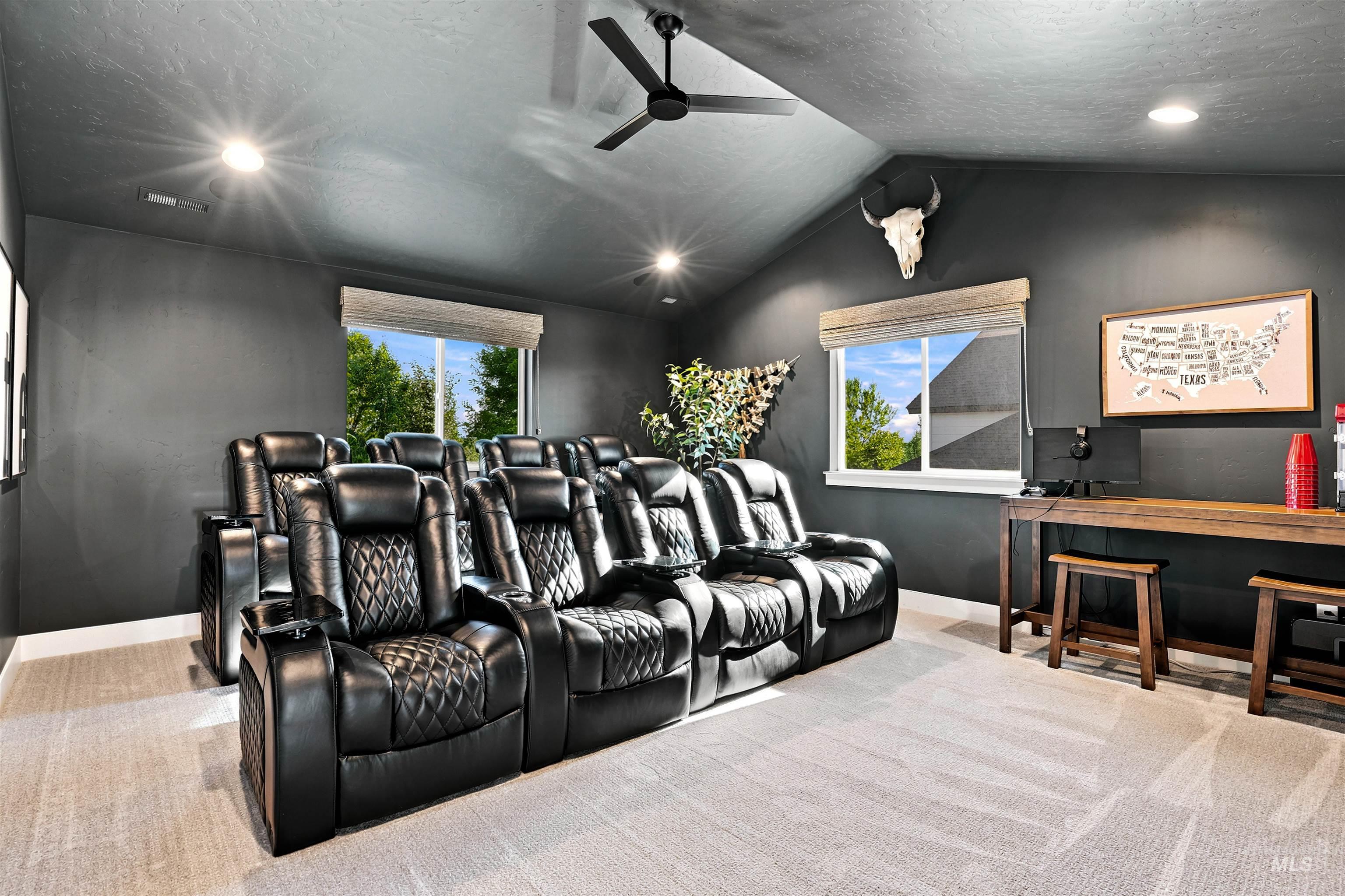 Dedicated media room featuring recessed lighting, a ceiling fan, and sloped ceilings